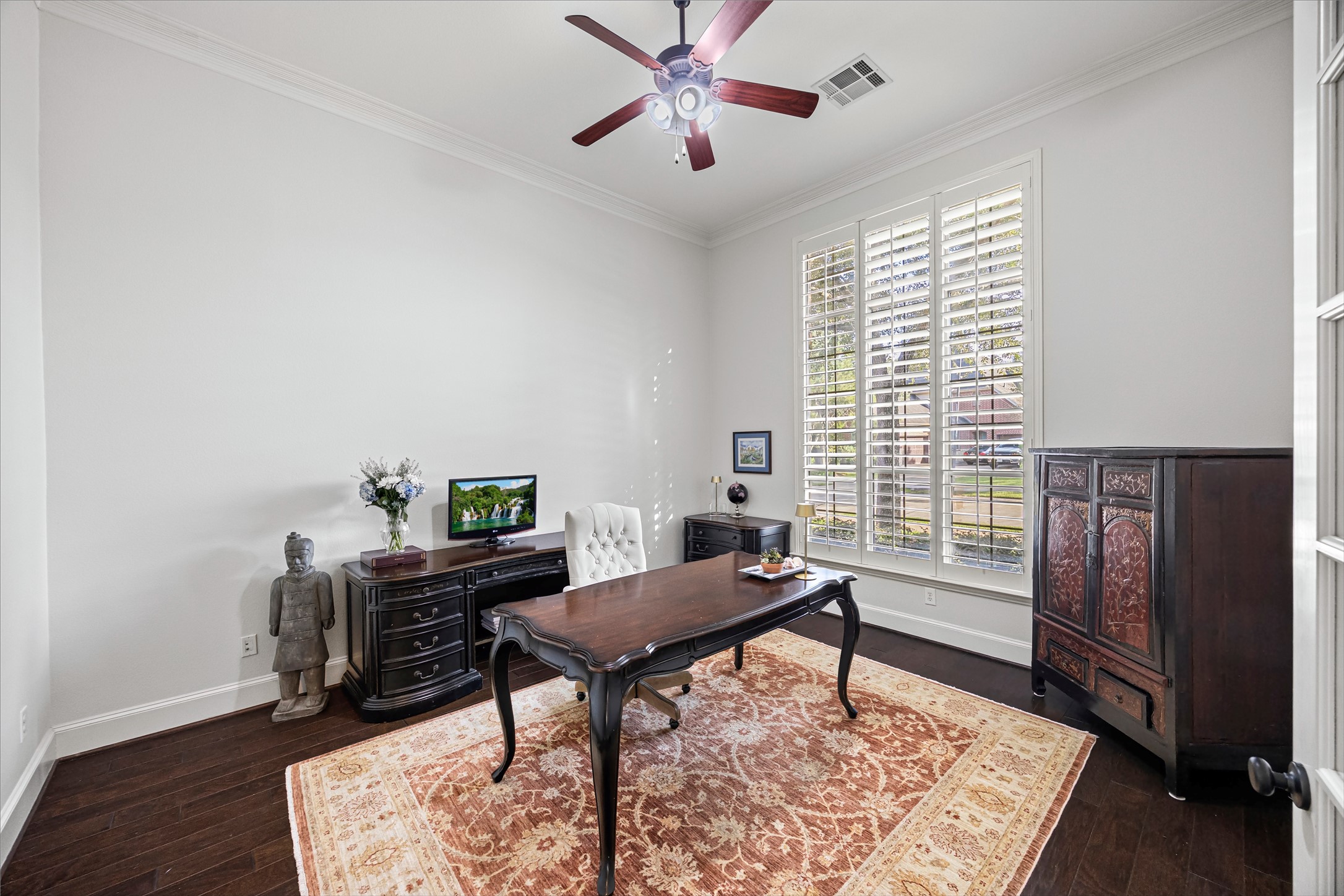 Executive study with plantation shutters, ceiling fan, and generous natural light. New windows (2024). All new lighting on dimmers.