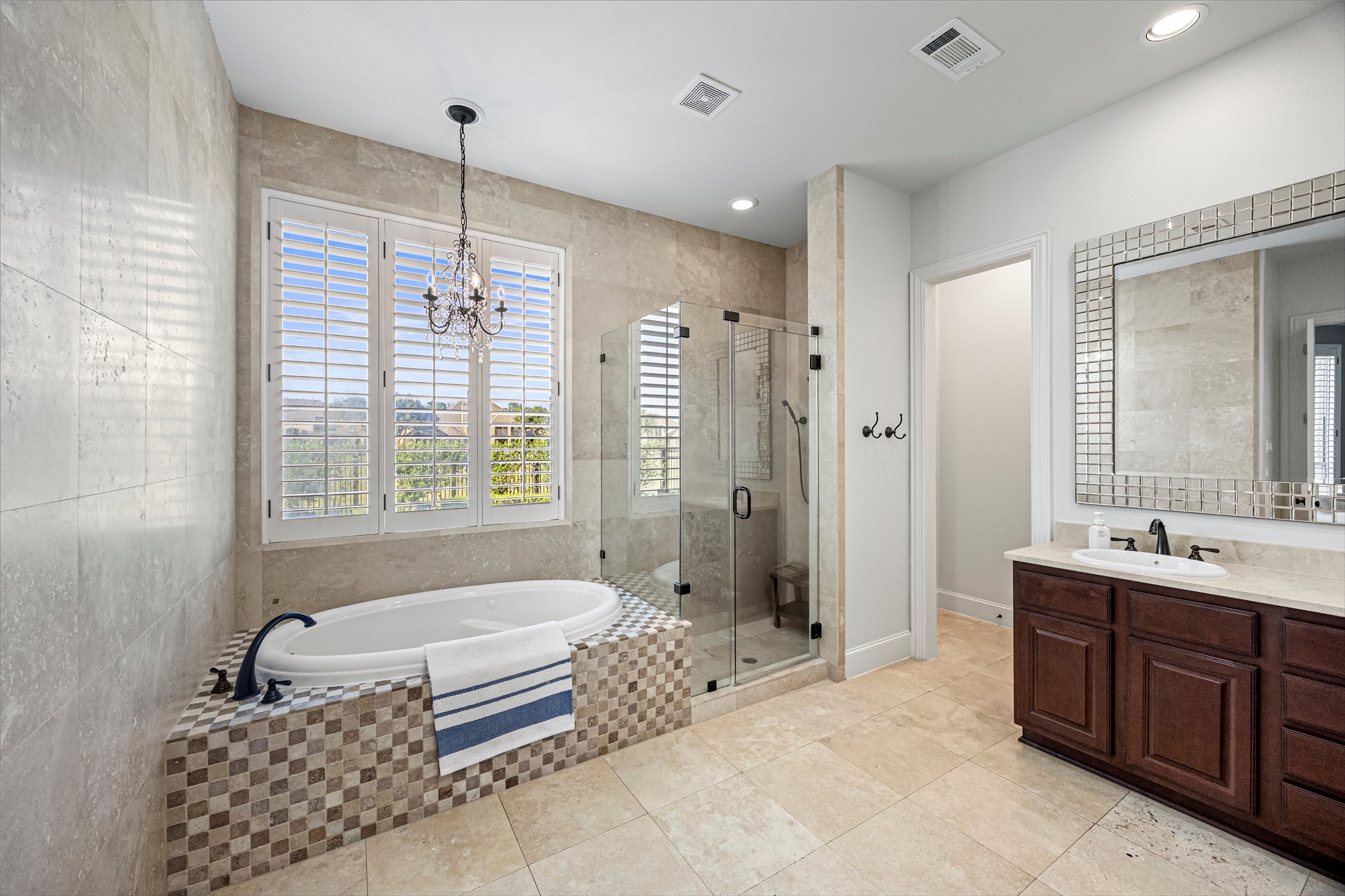 Spa-inspired primary bath with freestanding soaking tub and elegant chandelier. All new lighting on dimmers. Updated paint throughout.