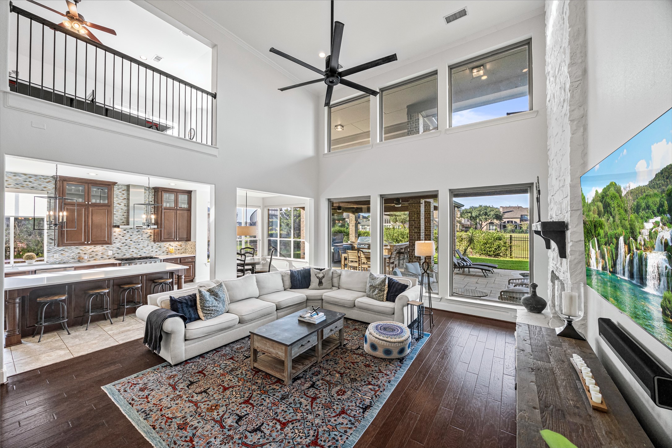 Two-story living room with dramatic upper-level overlook and abundant natural light. New windows (2024). Built-in speakers in living room.