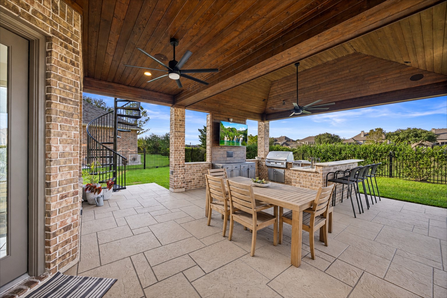 Covered patio with ceiling fan, outdoor dining space, and sweeping backyard views. Fans, exterior surround sound, and roller shades.