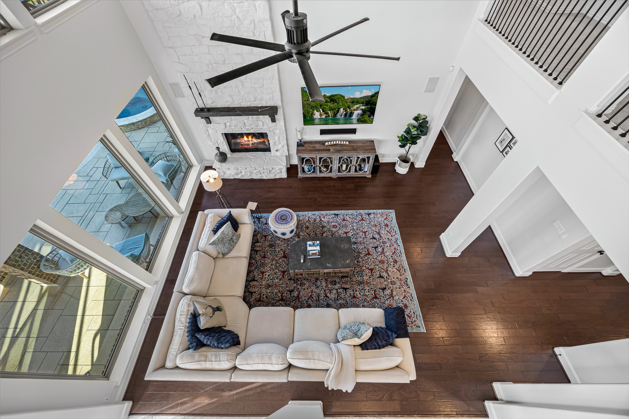 Dramatic view from the upper level overlooking the two-story living room. Stairs redone (2020). All new lighting on dimmers.