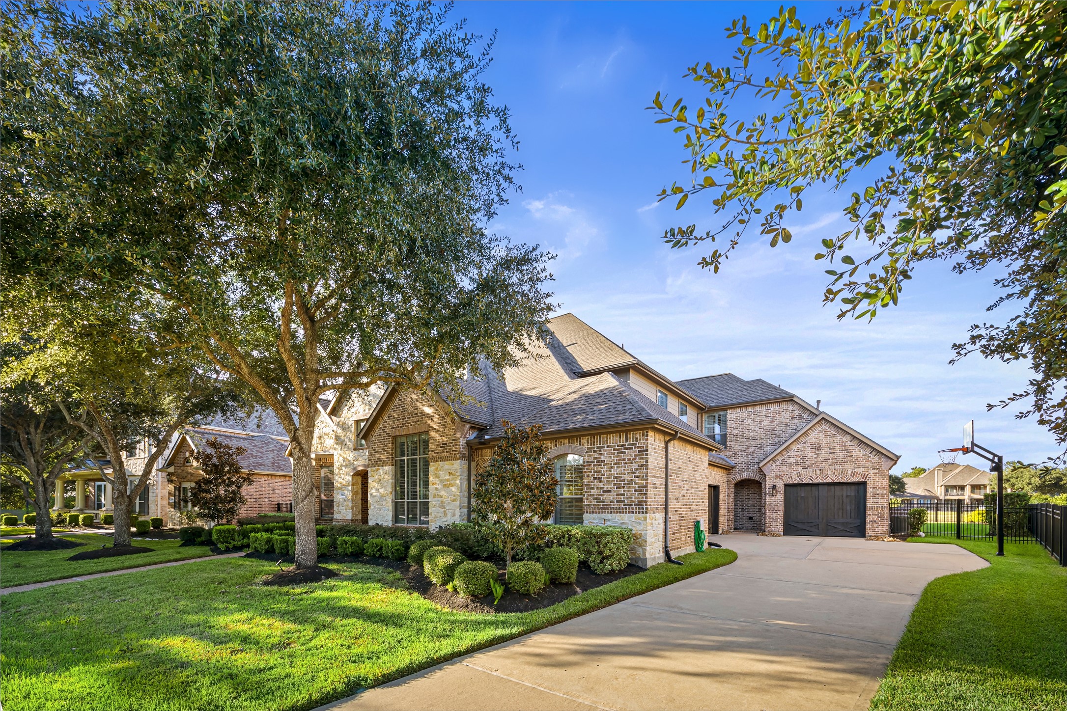 Graceful exterior view showcasing the home's architecture, lush lawn, and extended driveway. New windows (2024).