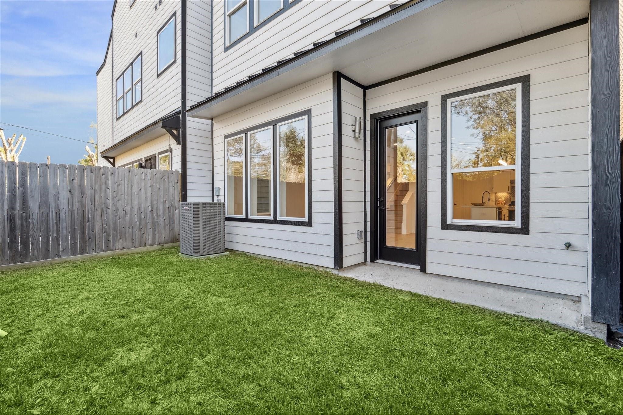 Spacious backyard with lush greenery and a low-maintenance setup, perfect for relaxing or entertaining.