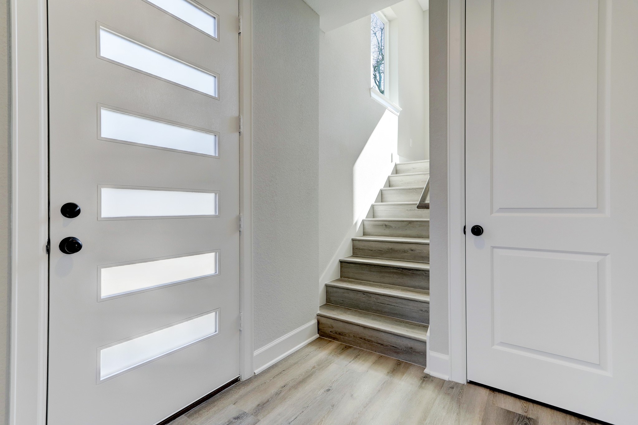 Welcoming entry with a modern front door, contemporary finishes, and convenient storage.