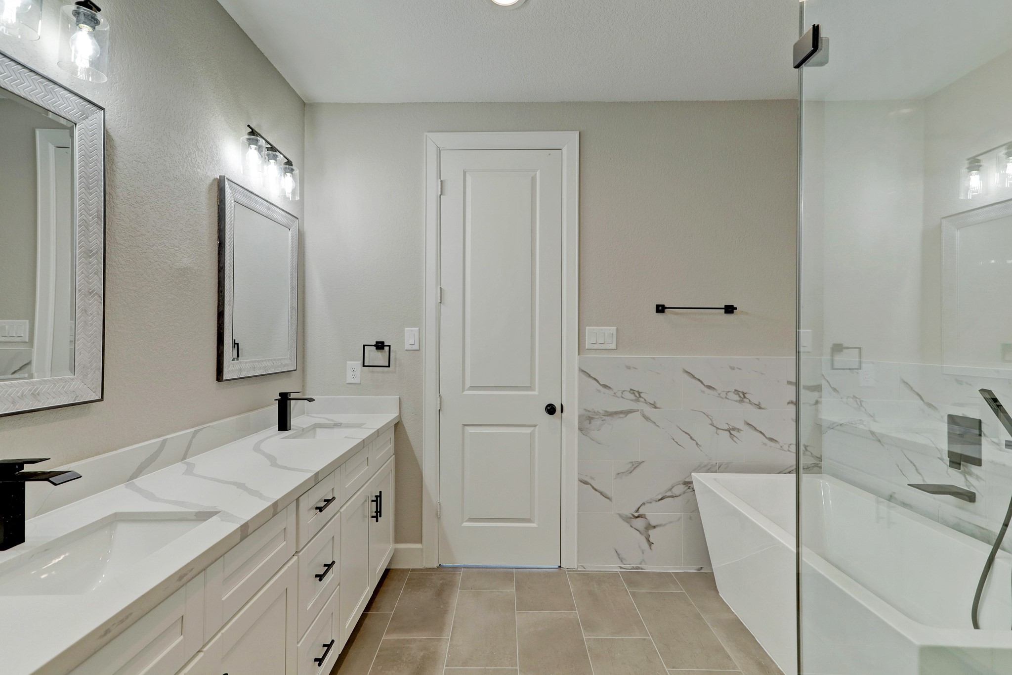 Primary bathroom features freestanding tub, shower, and double sinks for the ultimate spa experience