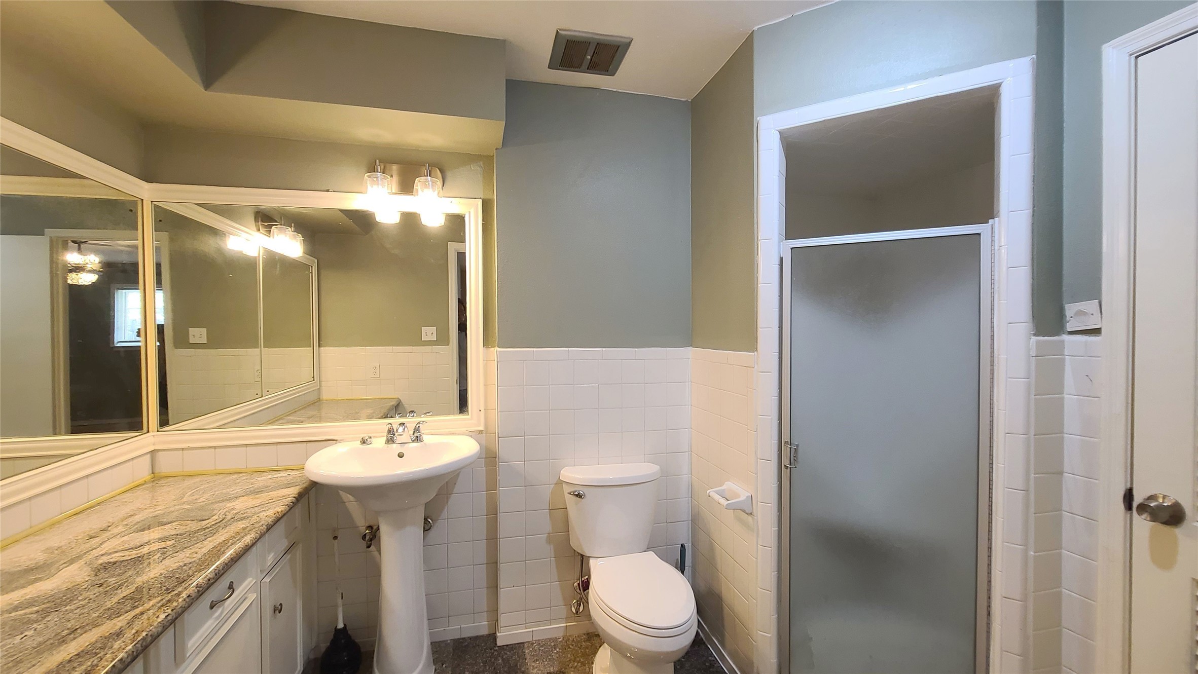 Step into the inviting primary bath featuring a sleek granite countertop and a spacious walk-in shower, perfect for unwinding in style.