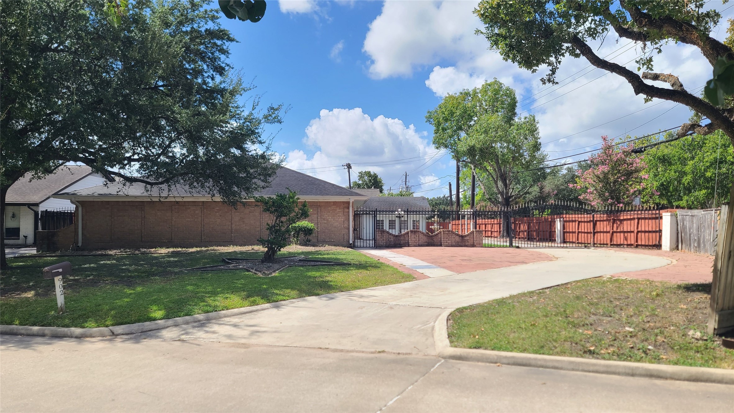 Experience elegance and privacy with this beautiful home, featuring a long driveway and a stately wrought iron gate.