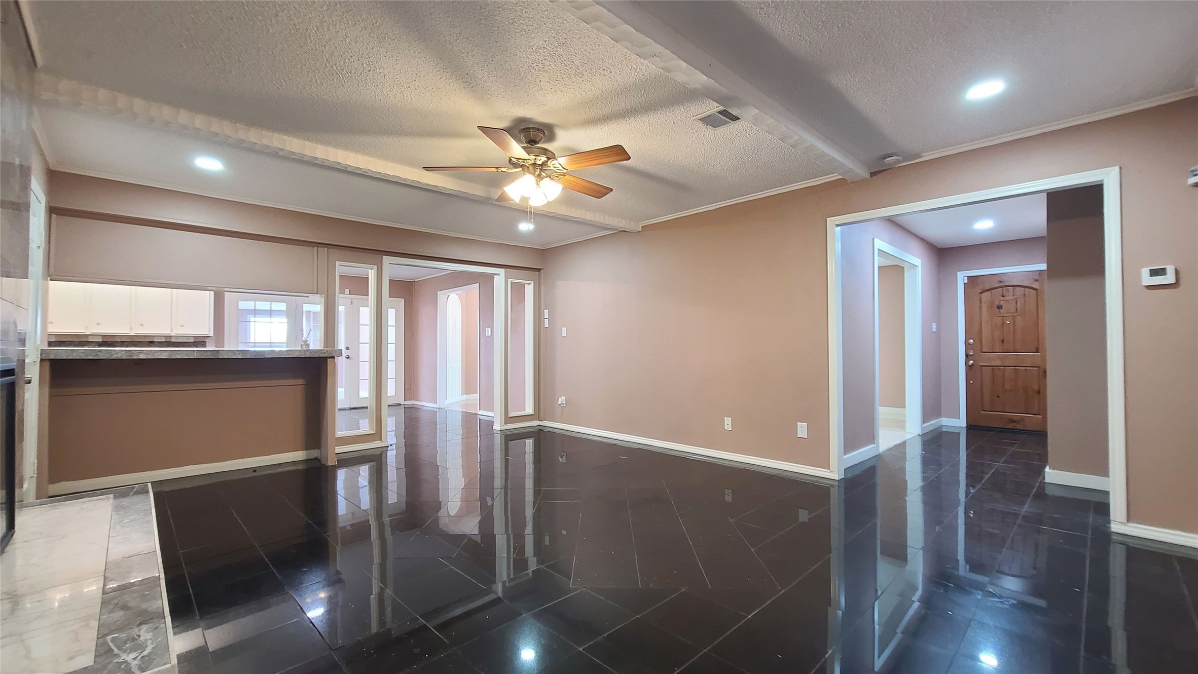 Step into an inviting family room where elegant built-in bookshelves and a cozy seating area create a perfect blend of warmth and sophistication, seamlessly guiding you toward the welcoming entrance.