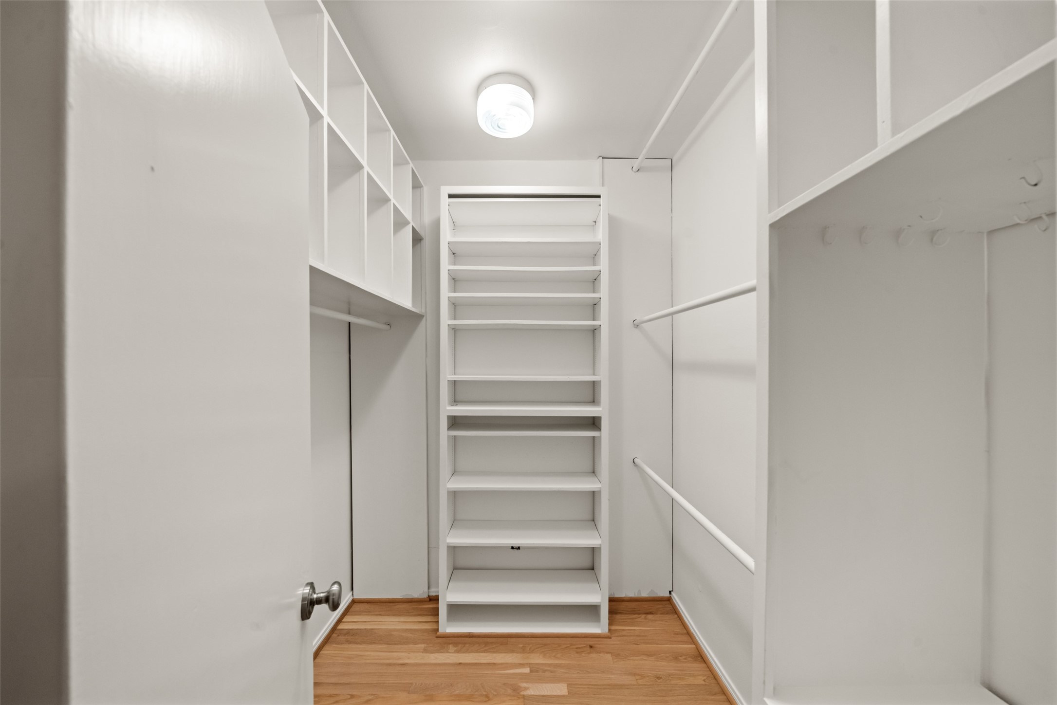 Primary walk-in closet with built-in shelving and hanging space.