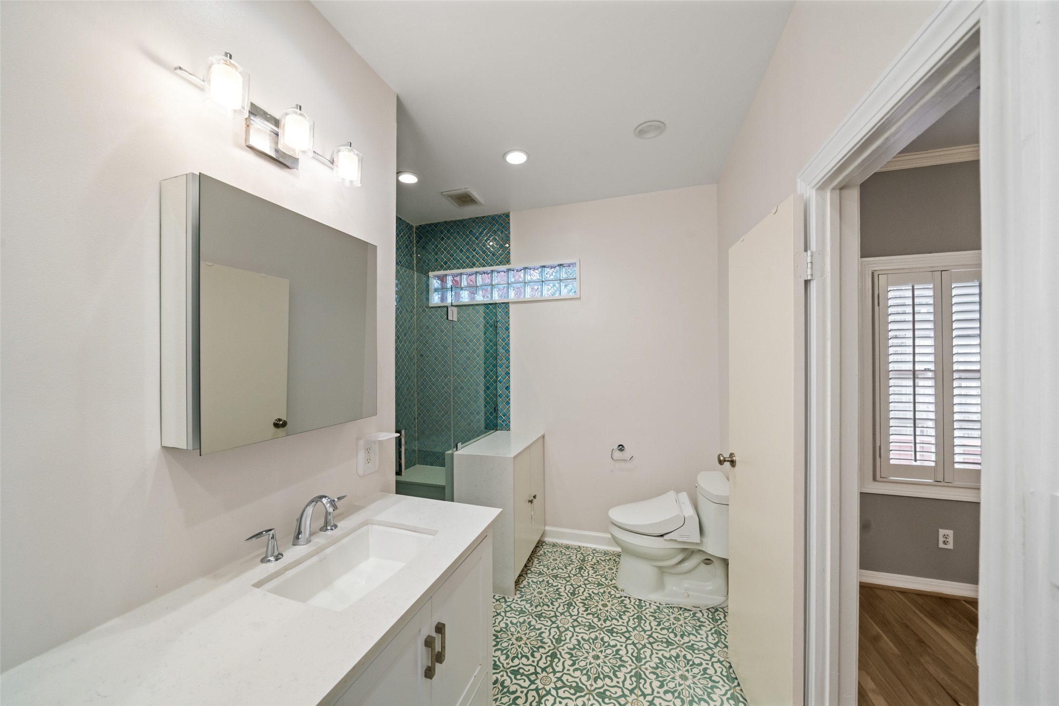 Anther view of the primary en-suite bath, featuring a glass-enclosed walk-in shower.