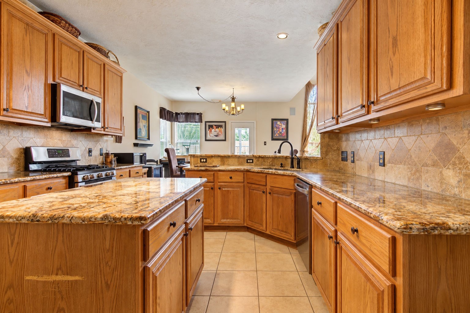 Kitchen with Island and granite countertops and stainless steel appliances.
