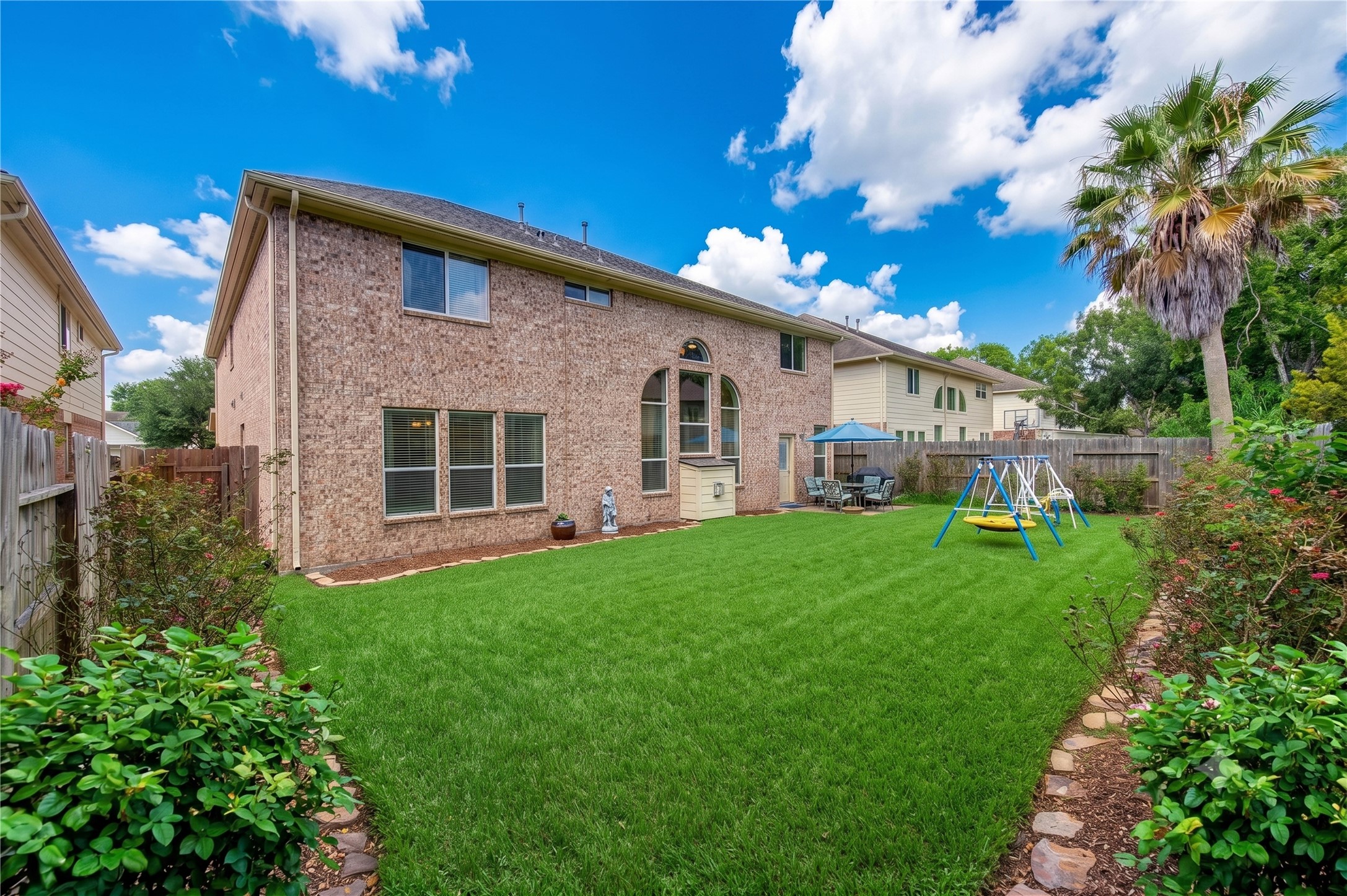 Expansive backyard with green lawn, perfect for family gatherings.
