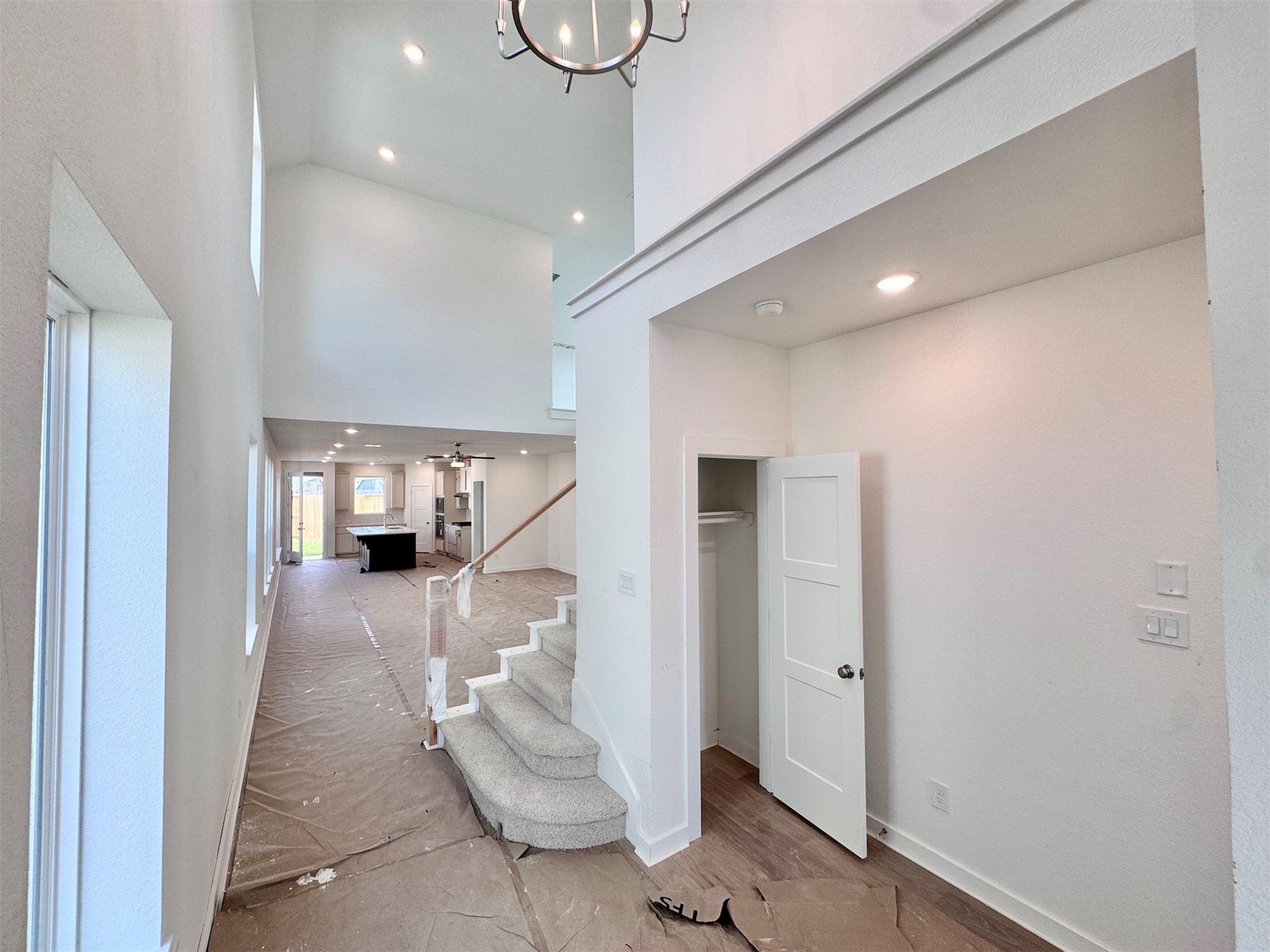 The foyer has natural light, near 20ft ceilings and the perfect drop zone pending installation on the right wall.