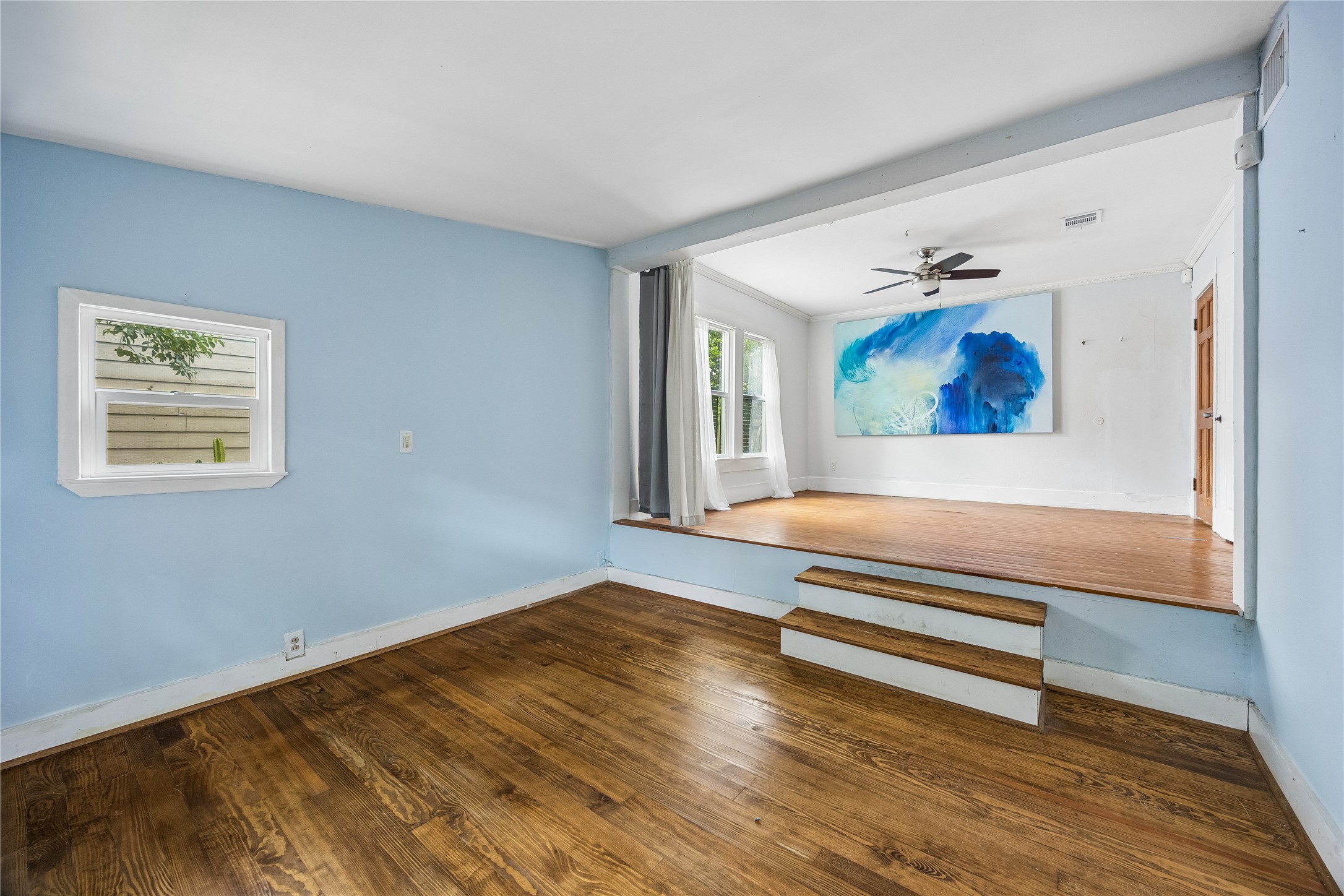 A unique split-level transition connects two bright, flexible spaces, giving the home an appealing sense of openness and architectural personality
