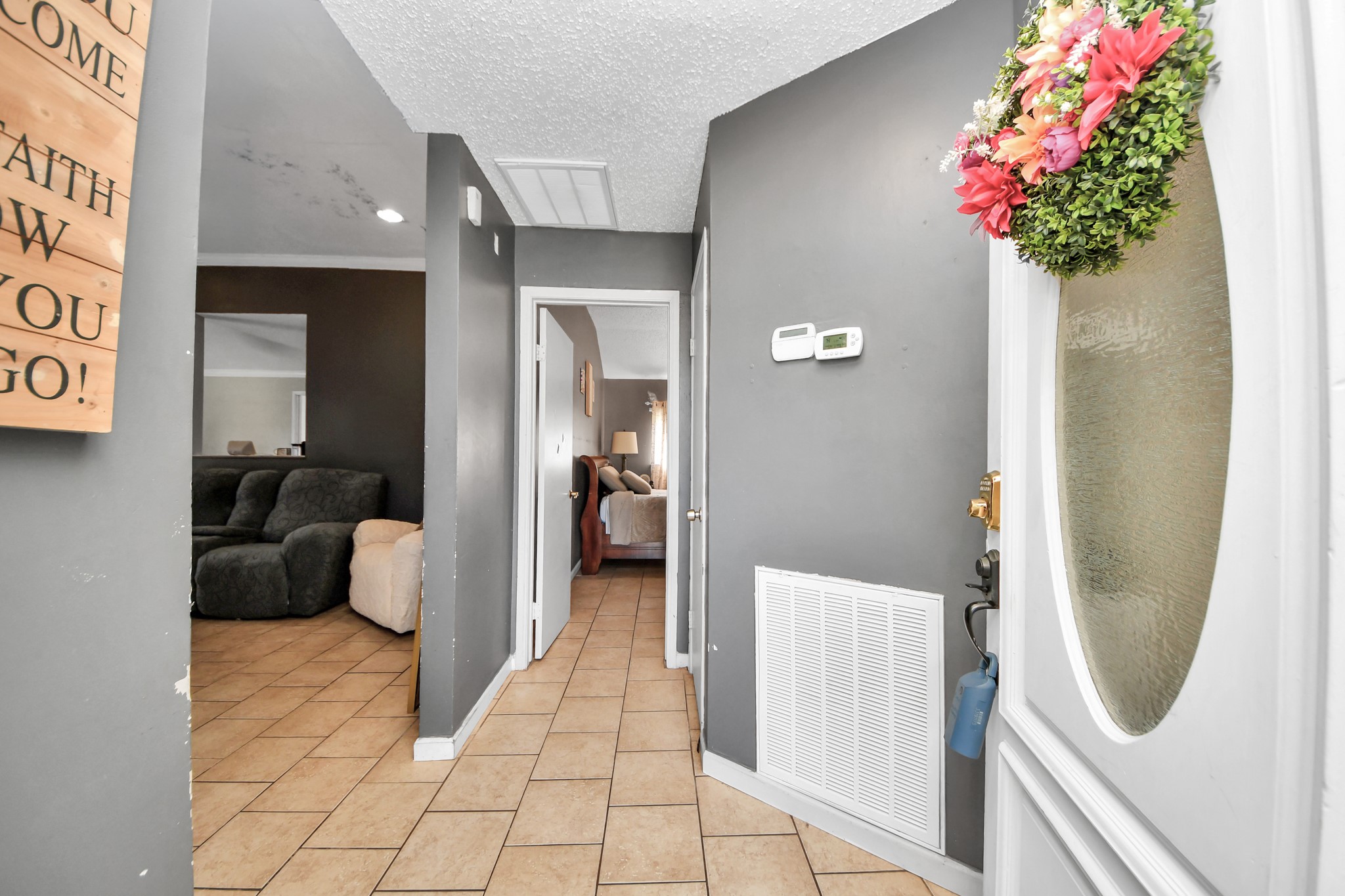 Step inside and be greeted by a beautiful front door featuring decorative oval glass, leading into a welcoming formal entry with tile flooring and neutral gray walls. The inviting layout flows seamlessly into the main living area, with convenient access to the bedrooms.