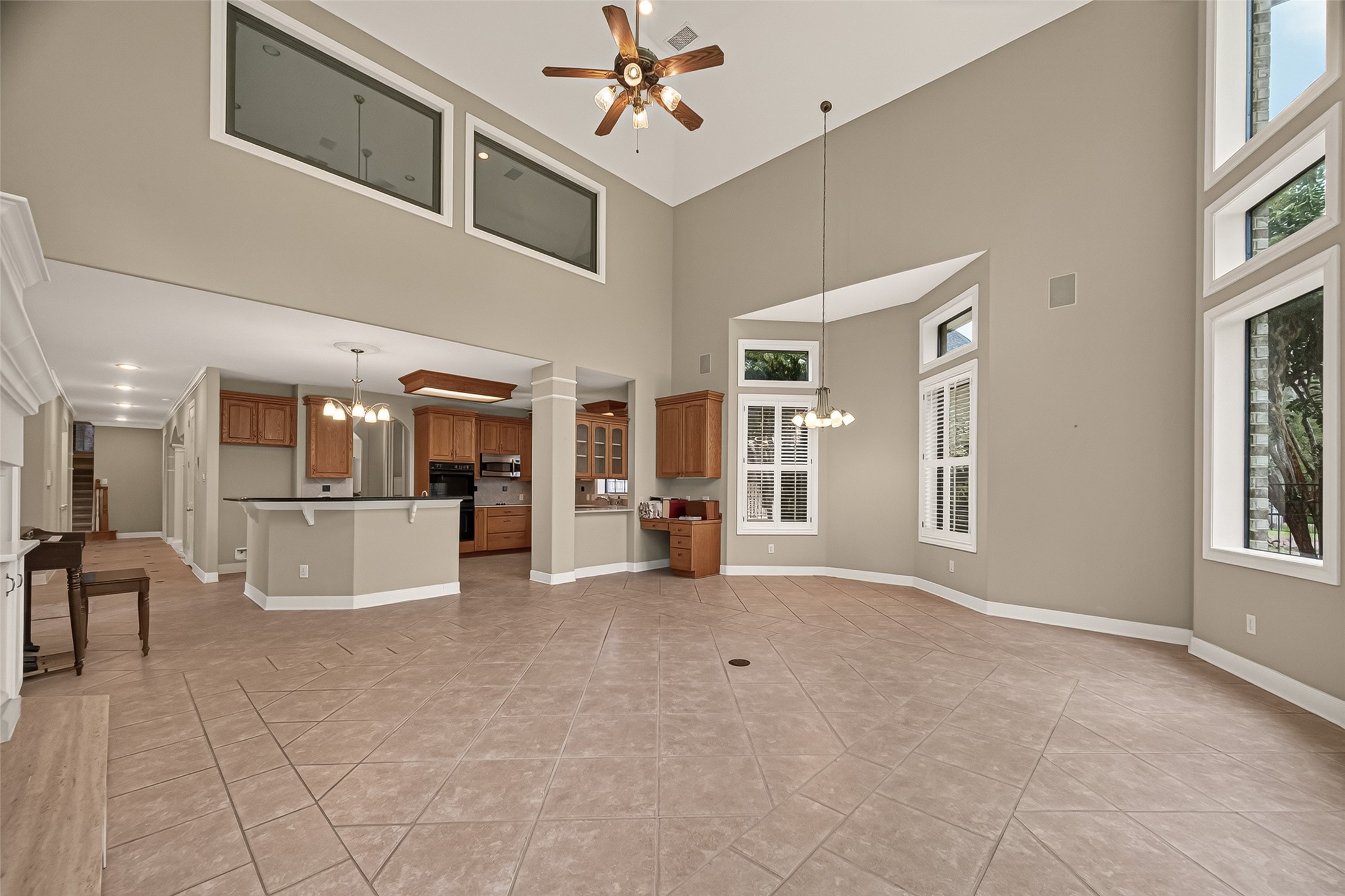 This view of the Kitchen and Breakfast Room from the Family Room.  Gorgeous transoms and plantation shutters. A small desk area with built-ins.