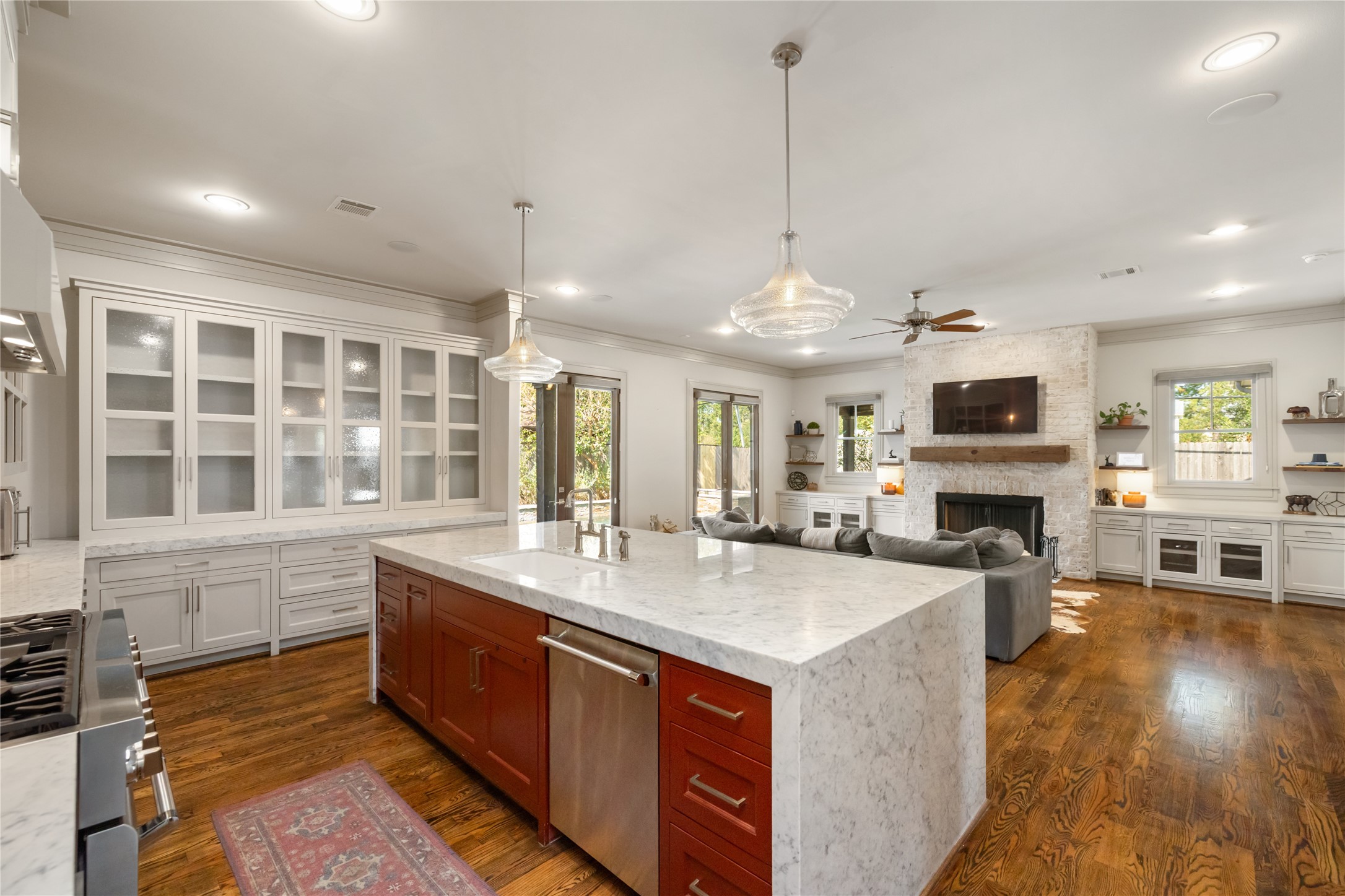 Awesome kitchen with a waterfall island, glass front cabinets, and a highend range