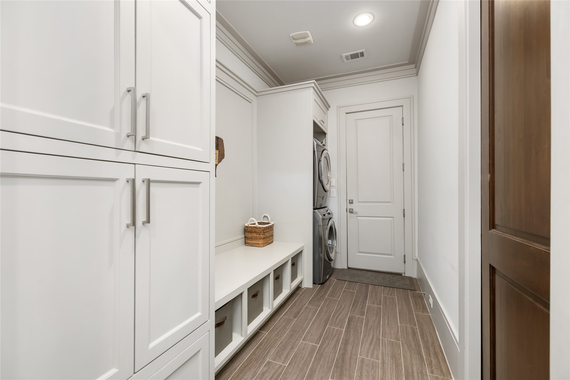The mudroom leads to the garage and has additional storage with the stacked laundry