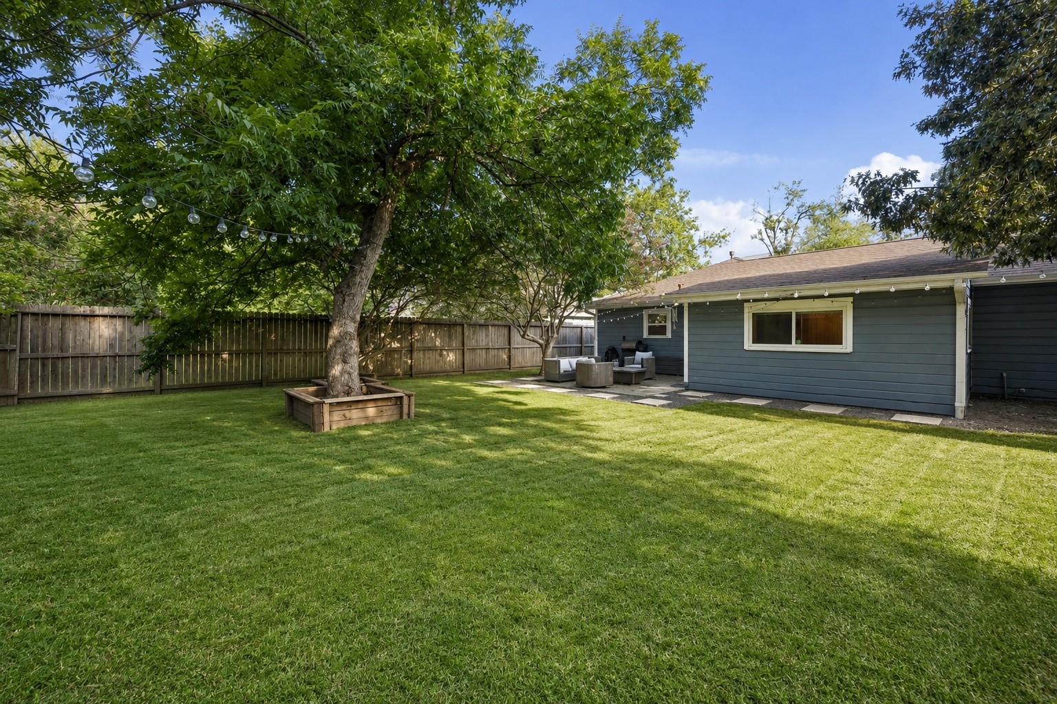 An expansive backyard offers endless possibilities, from hosting gatherings beneath the mature shade trees to creating your own garden or play area. Freshly manicured grass and multiple entertaining spaces make this outdoor setting just as enjoyable as the home itself.