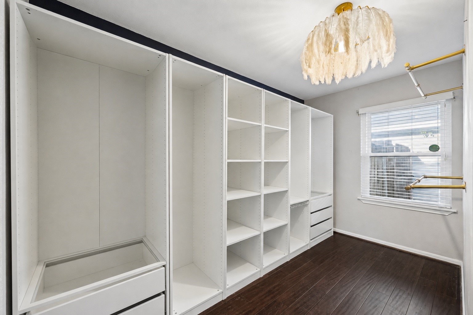 A custom walk in closet offers an impressive combination of hanging space, shelving, drawers, and organization to keep everything neatly within reach. Clean lines and a thoughtfully designed layout make daily routines feel effortless.