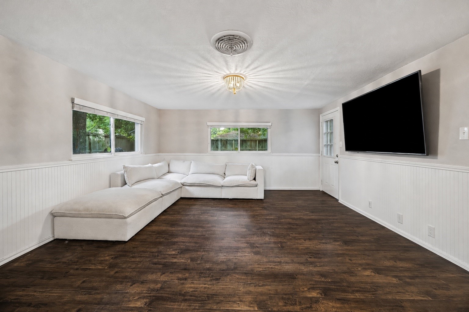 Natural light pours into this spacious family room, offering plenty of room to relax, host movie nights, or gather with friends. Large windows, durable flooring, and direct access to the backyard create an inviting space that blends indoor comfort with outdoor living. Natural light pours into this spacious family room, offering plenty of room to relax, host movie nights, or gather with friends. Large windows, durable flooring, and direct access to the backyard create an inviting space that blends indoor comfort with outdoor living.