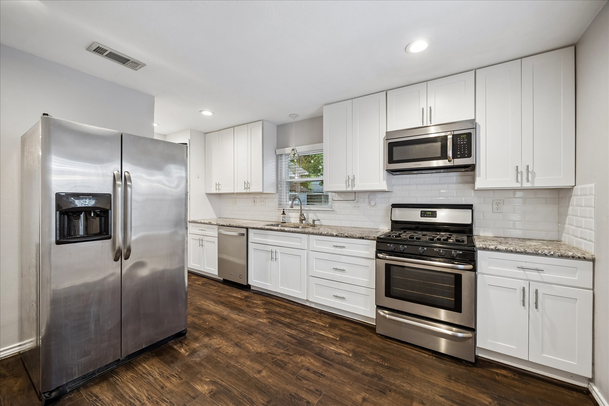 Bright white shaker cabinetry extends to the ceiling, offering abundant storage alongside granite countertops, a subway tile backsplash, and stainless steel appliances. A thoughtful layout provides generous prep space while keeping the kitchen open to the adjoining breakfast nook and living areas. Bright white shaker cabinetry extends to the ceiling, offering abundant storage alongside granite countertops, a subway tile backsplash, and stainless steel appliances. A thoughtful layout provides generous prep space while keeping the kitchen open to the adjoining breakfast nook and living areas.