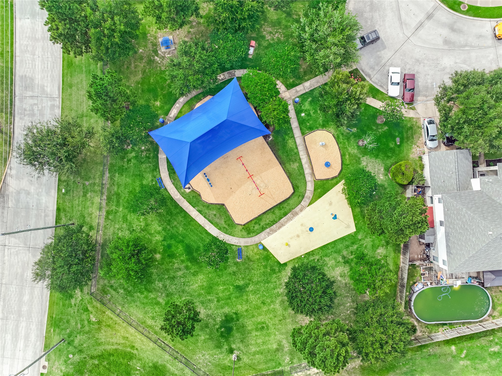 Drone view of the neighborhood amenities highlighting the playground, and surrounding greenery.