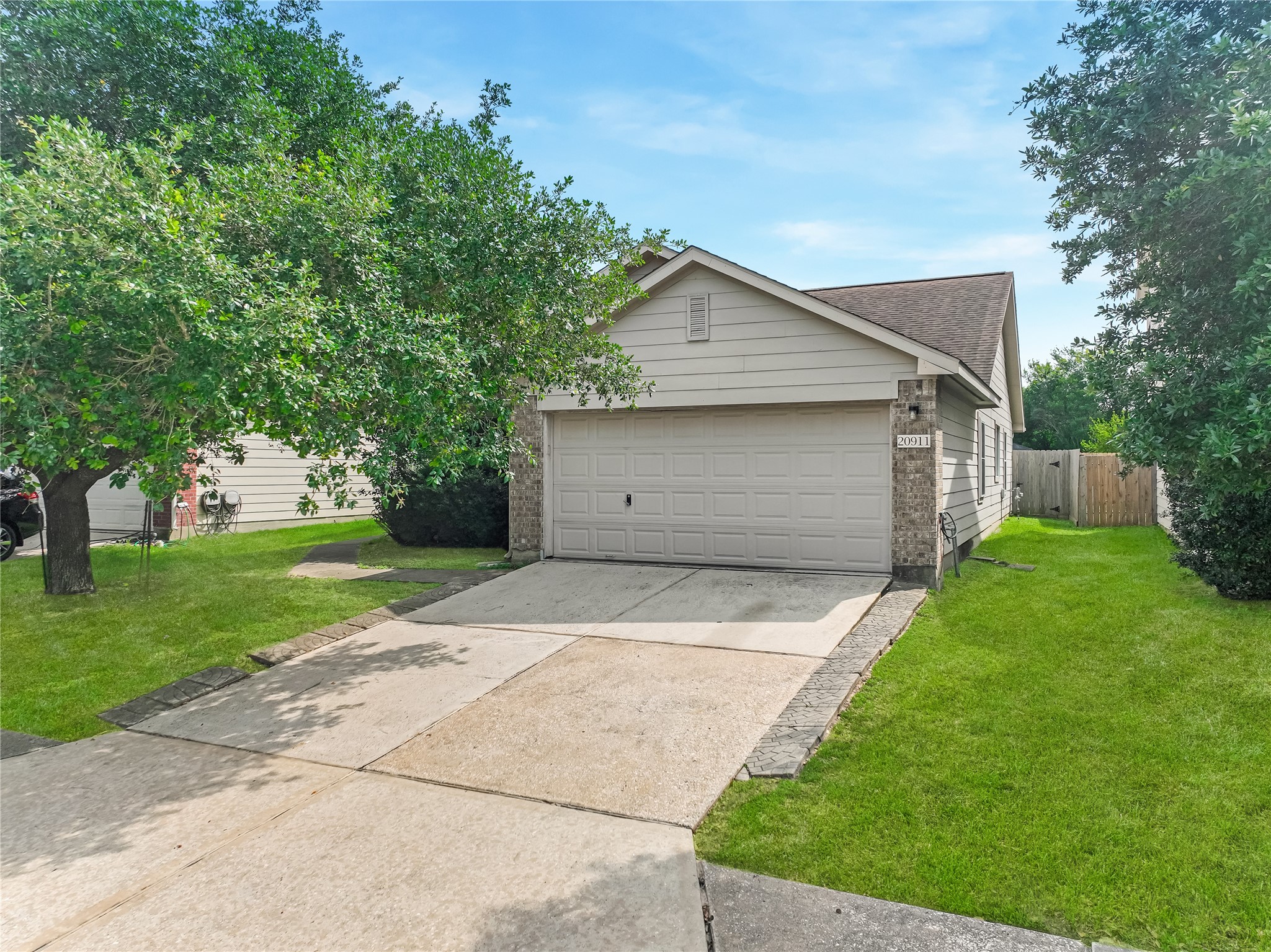 Front exterior view with a driveway, attached garage, and landscaped front yard.