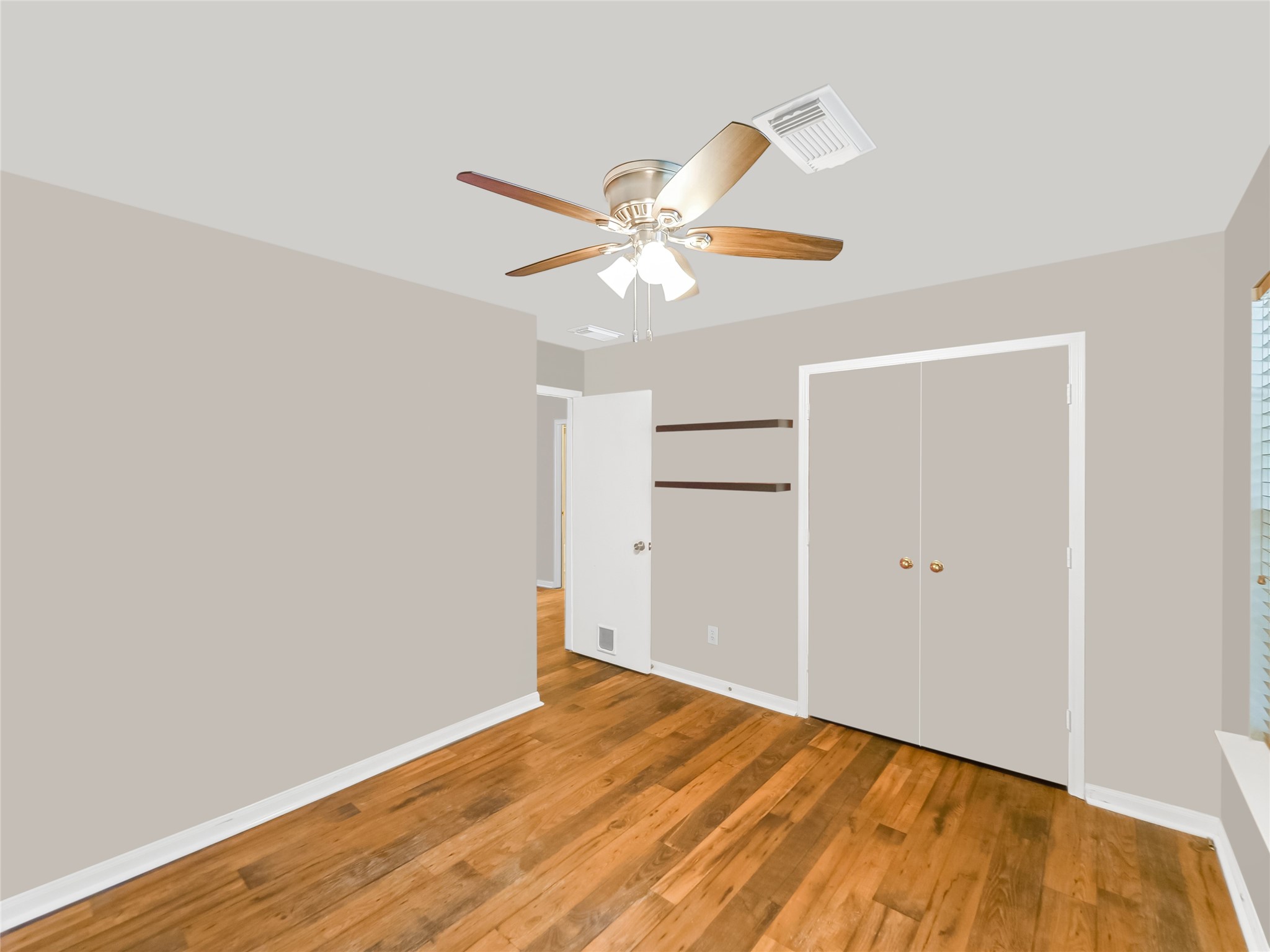 Bedroom with a ceiling fan, and a large window.