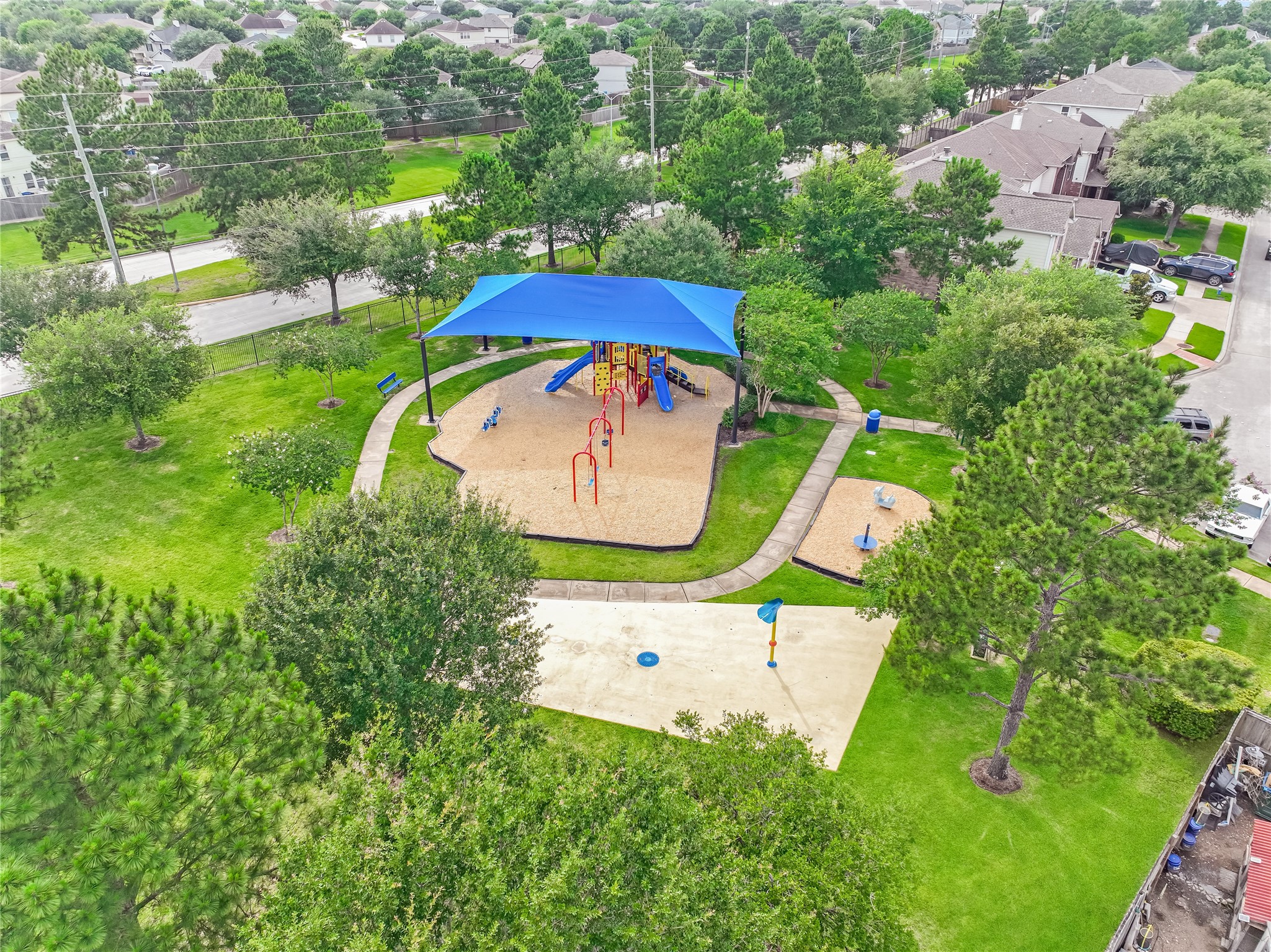 Drone view of the neighborhood amenities highlighting the playground, and surrounding greenery.