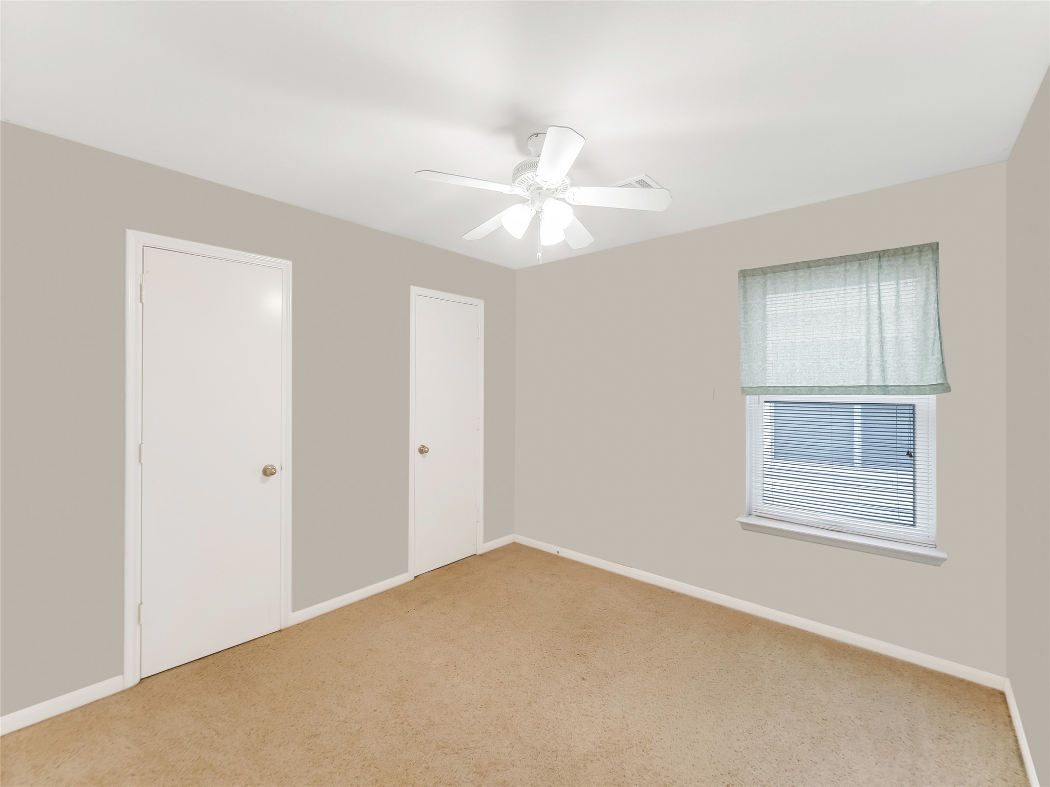 Bedroom with a ceiling fan, and a large window.