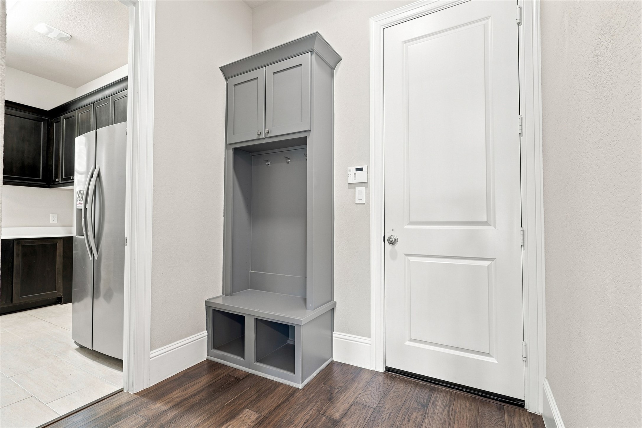 A practical built-in storage area greets you at the garage entry, offering an organized drop zone and seamless access to the utility room.