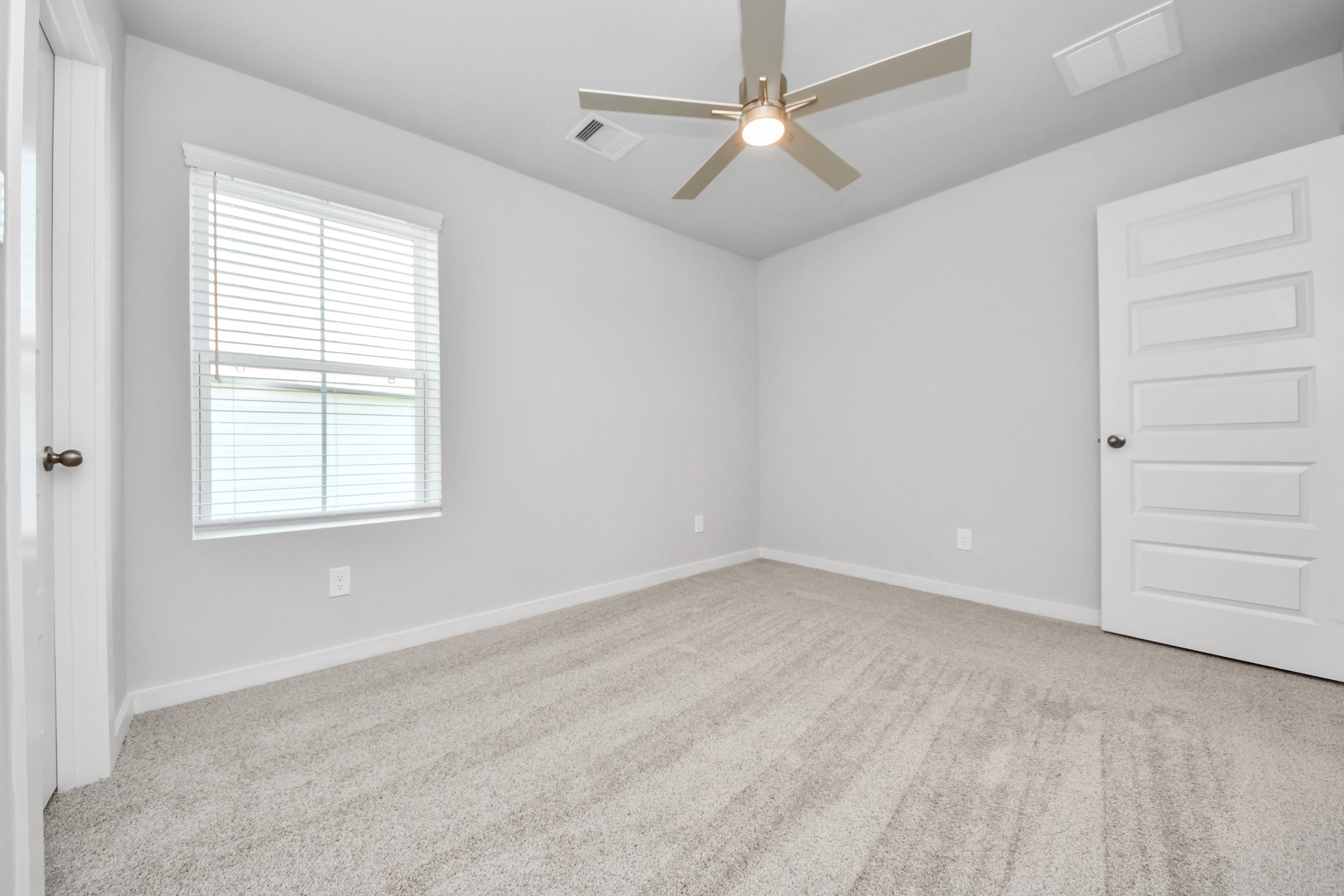 Secondary bedroom features plush carpeting, large windows that let in plenty of natural light, bright paint, and spacious closets. Sample photo of completed home with similar floor plan. Actual colors and selections may vary.