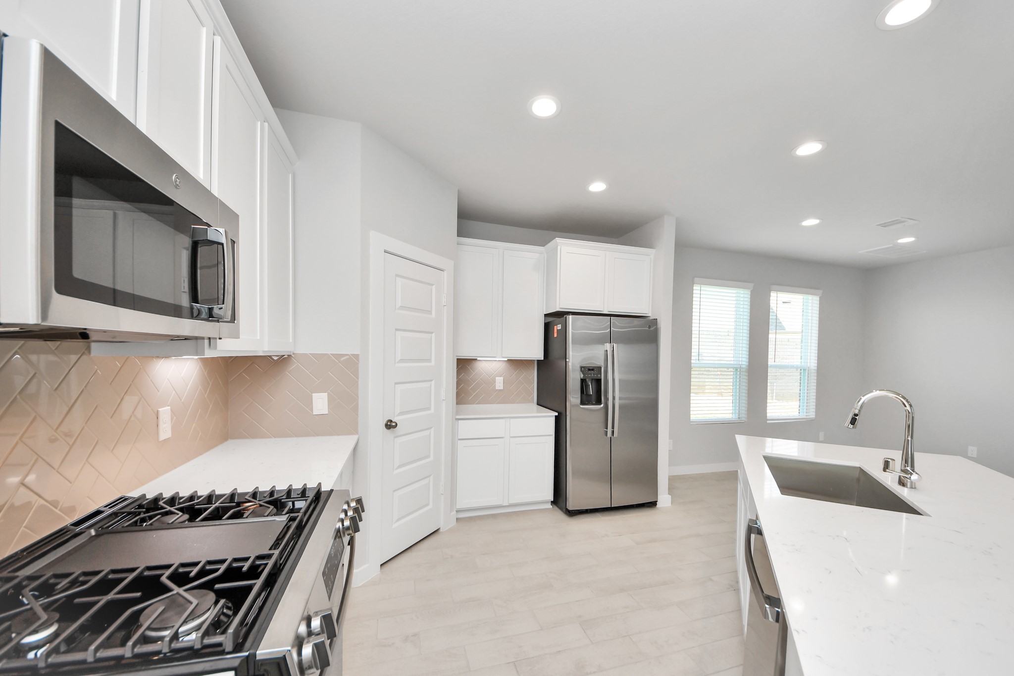 Discover another perspective of this stunning kitchen, generously appointed with an abundance of counter space. Sample photo of completed home with similar floor plan. Actual colors and selections may vary.