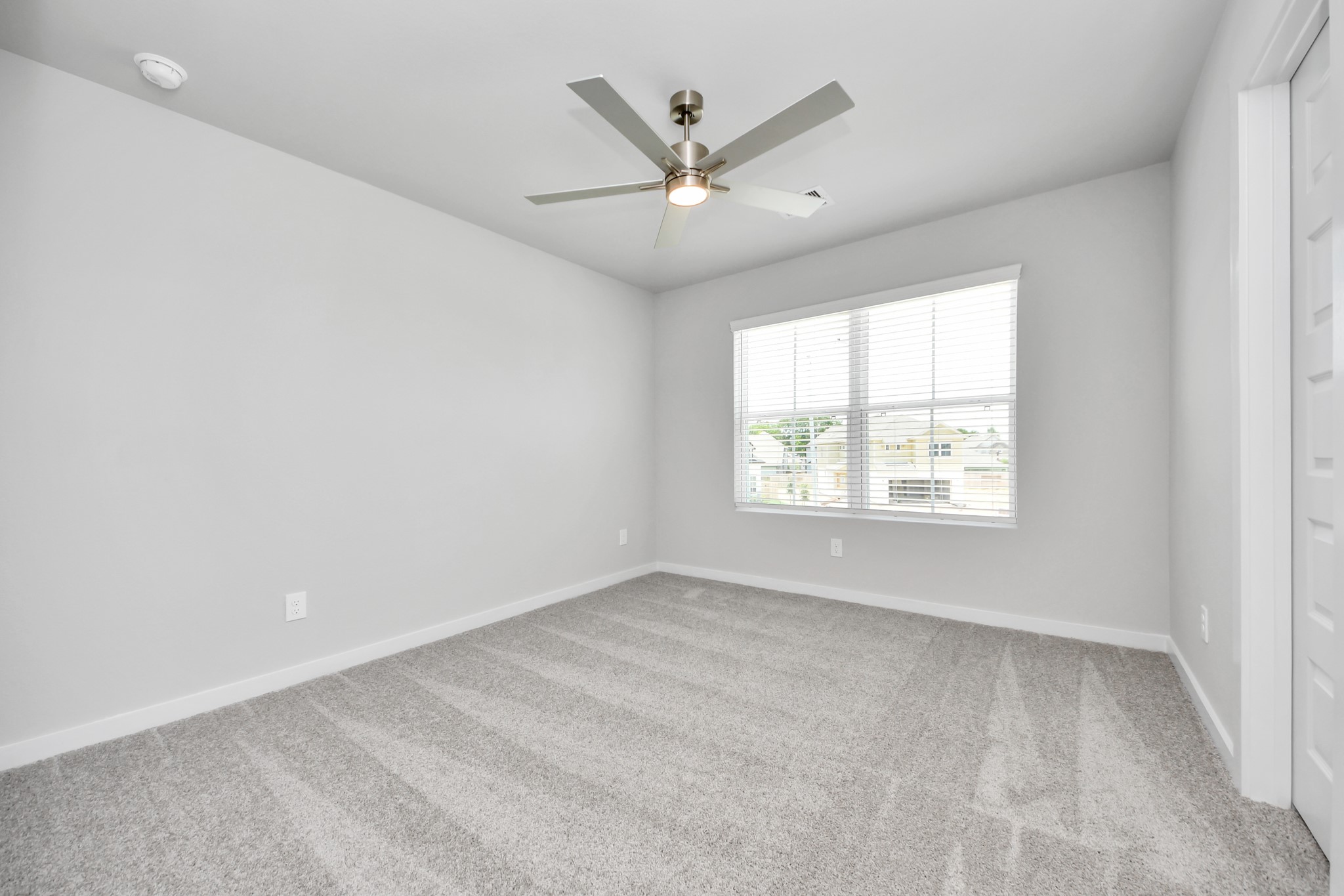Secondary bedroom features plush carpeting, large windows that let in plenty of natural light, bright paint, and spacious closets. Sample photo of completed home with similar floor plan. Actual colors and selections may vary.