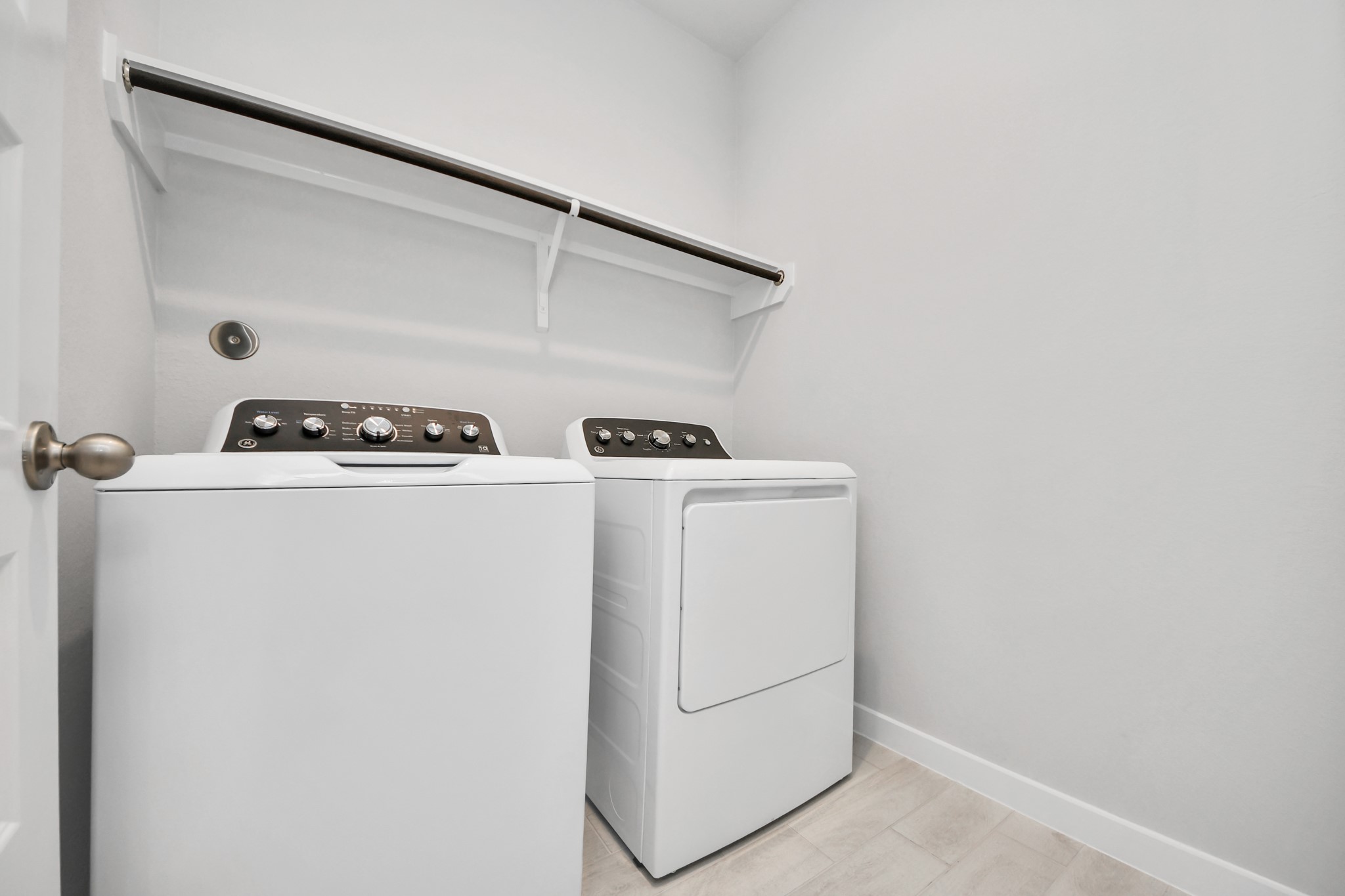 A perfect blend of functionality and comfort. Capture the essence of easy living with a first-floor laundry room, thoughtfully equipped with shelving for effortless organization. Both electric and gas connections available. Sample photo of completed home with similar floor plan. Actual colors and selections may vary.