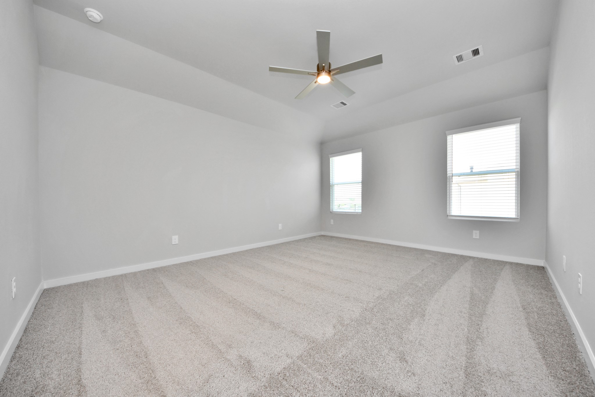 Escape to tranquility in this spacious primary room, adorned with plush carpeting and bathed in the soothing hues of warm paint colors, creating a cozy retreat for relaxation. Sample photo of completed home with similar floor plan. Actual colors and selections may vary.