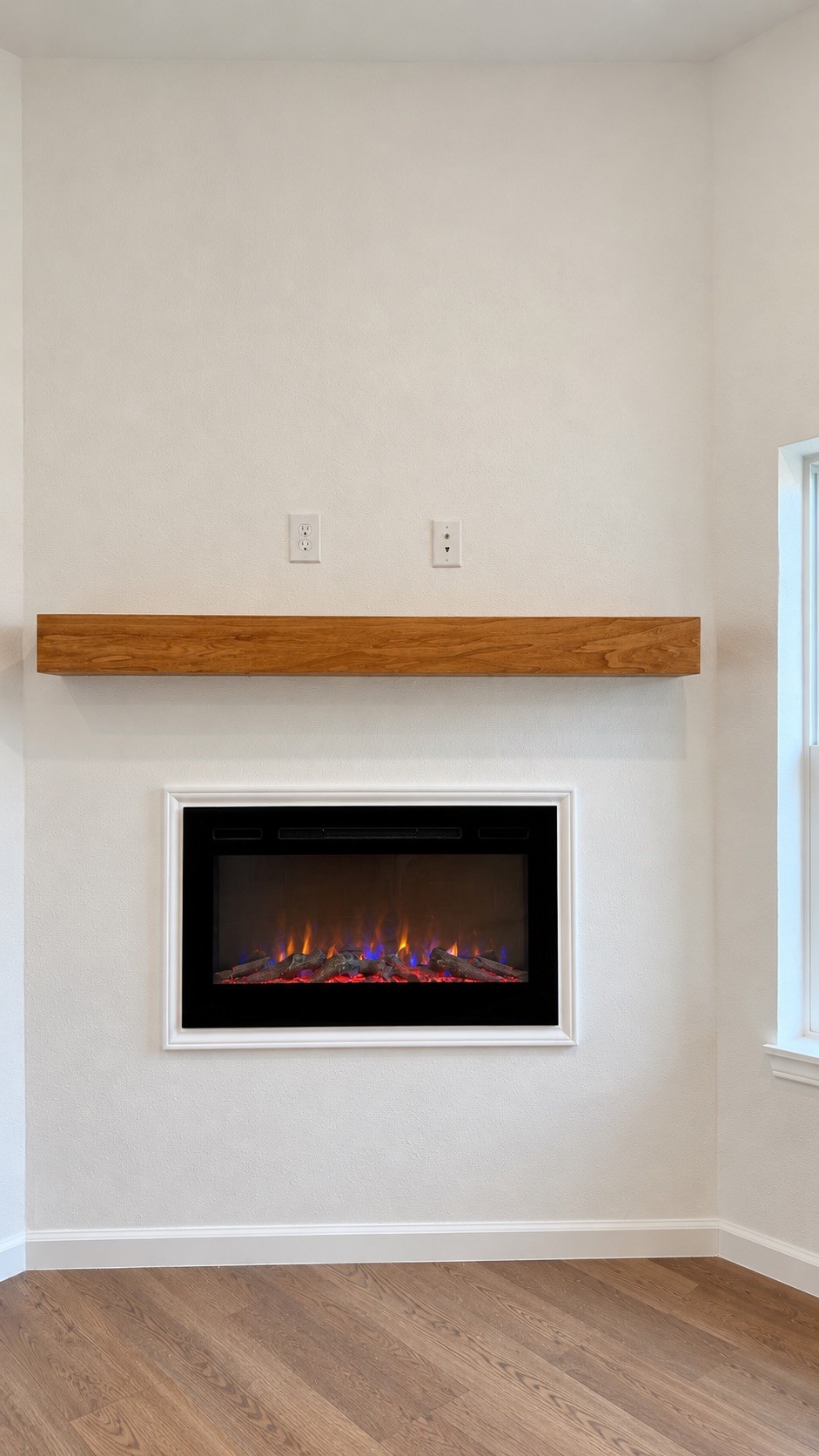 Modern electric fireplace featuring a stylish wood accent wall for a warm and contemporary look.