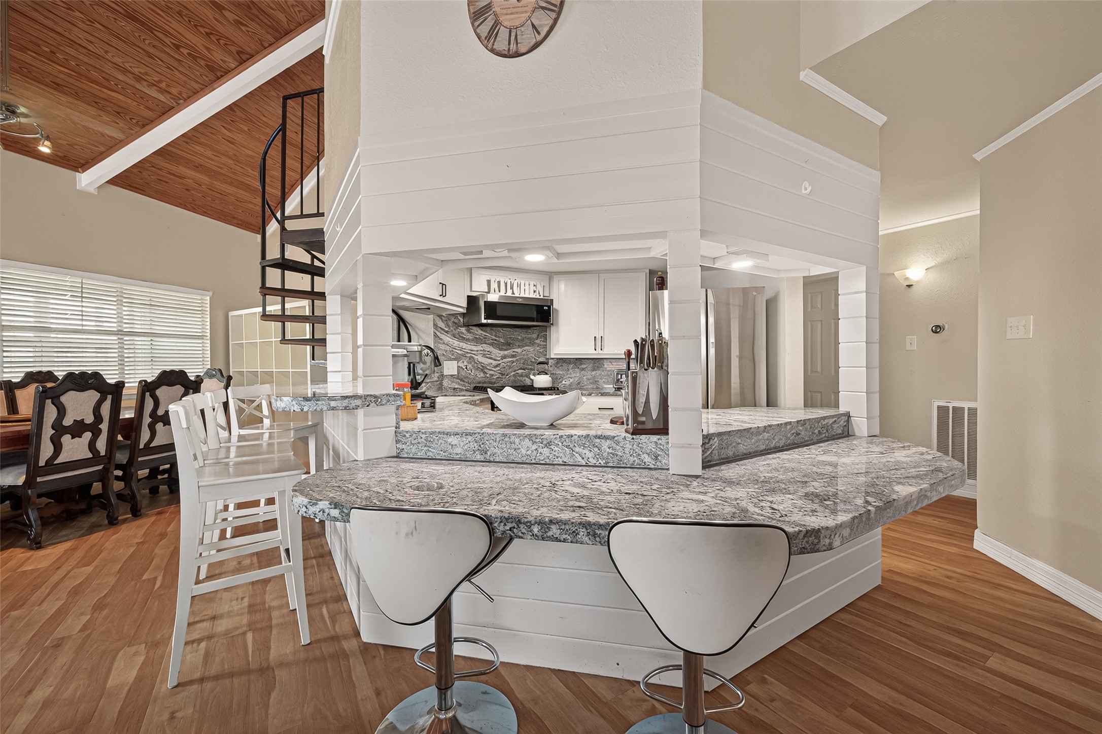 The home's extraordinary centerpiecea hexagonal culinary station outfitted with dual-tier bar seating and flow-through counter windows.