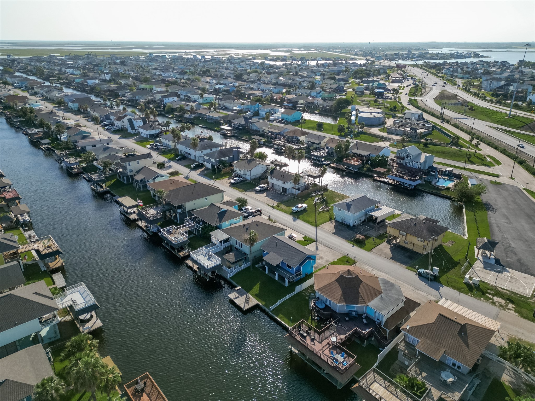 Picturesque canal-community livingshowcasing pristine, neatly arranged waterfront properties and tranquil, tree-lined residential streets.