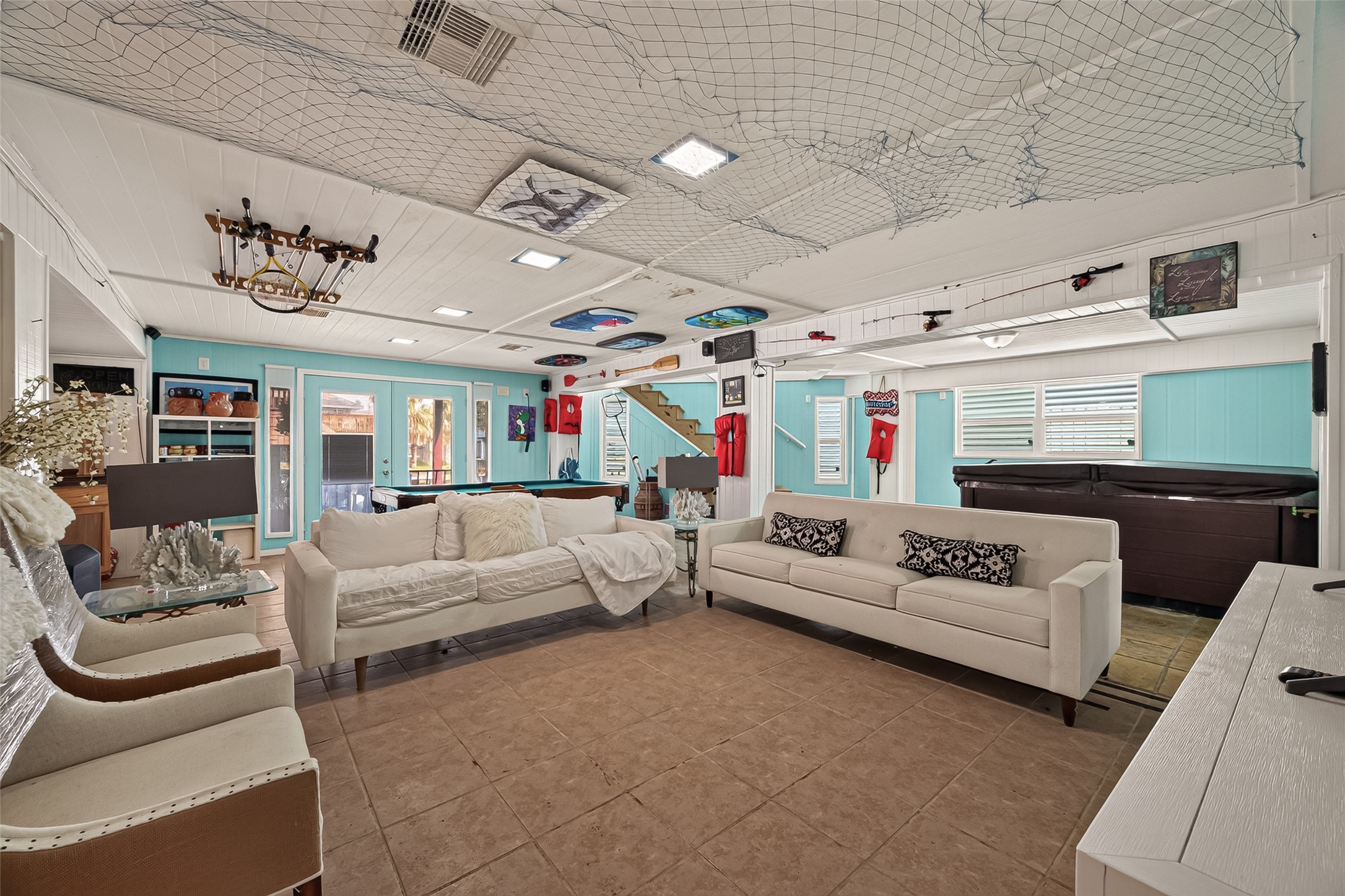 The ultimate party zonea sprawling coastal-themed social lounge equipped with a full-sized pool table, relaxing hot tub, and boundless room for entertaining.