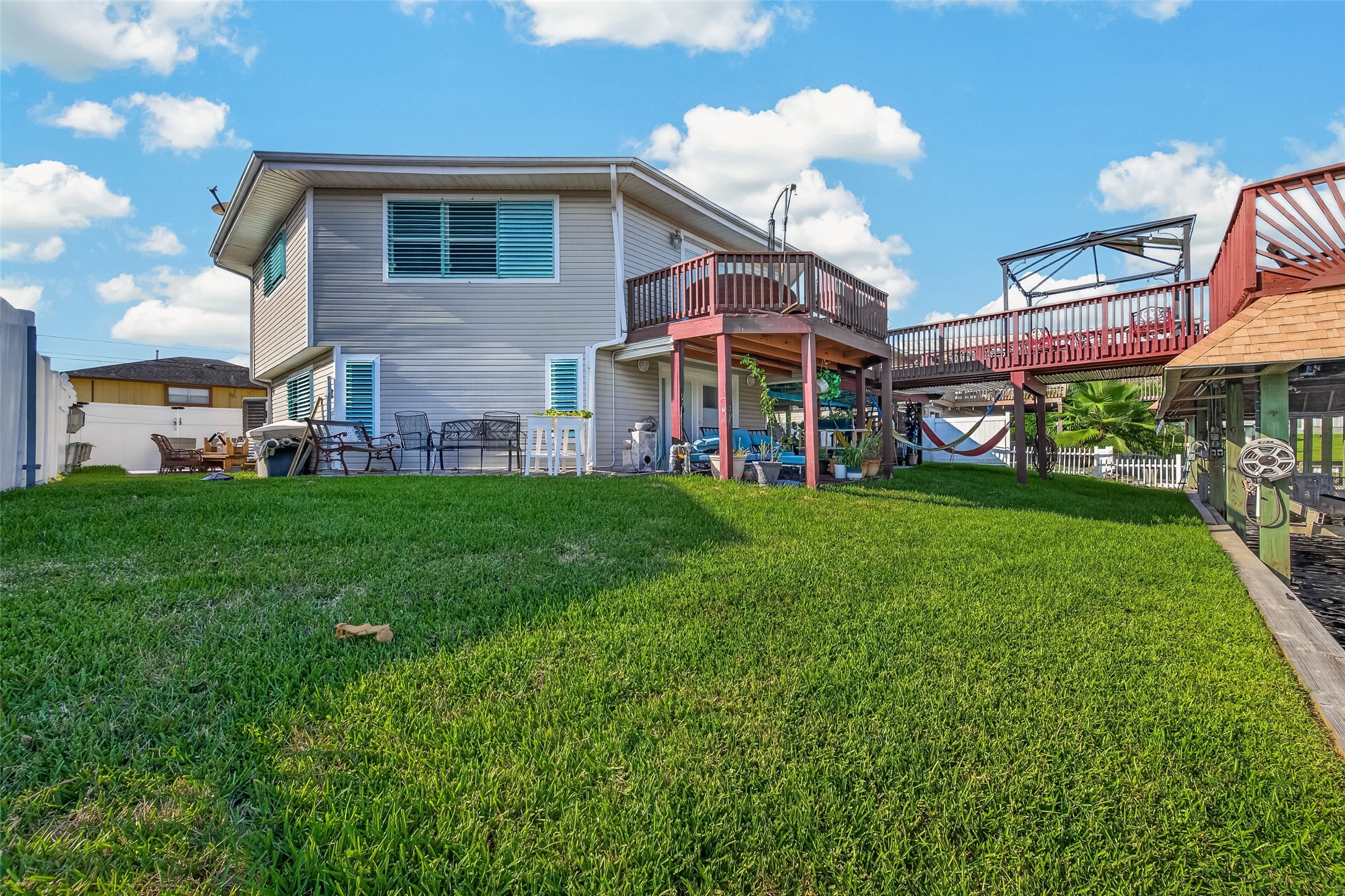 Multi-tiered waterfront living on full displaya sweeping view from the grassy lawn capturing both upper and lower party decks positioned directly over the canal.