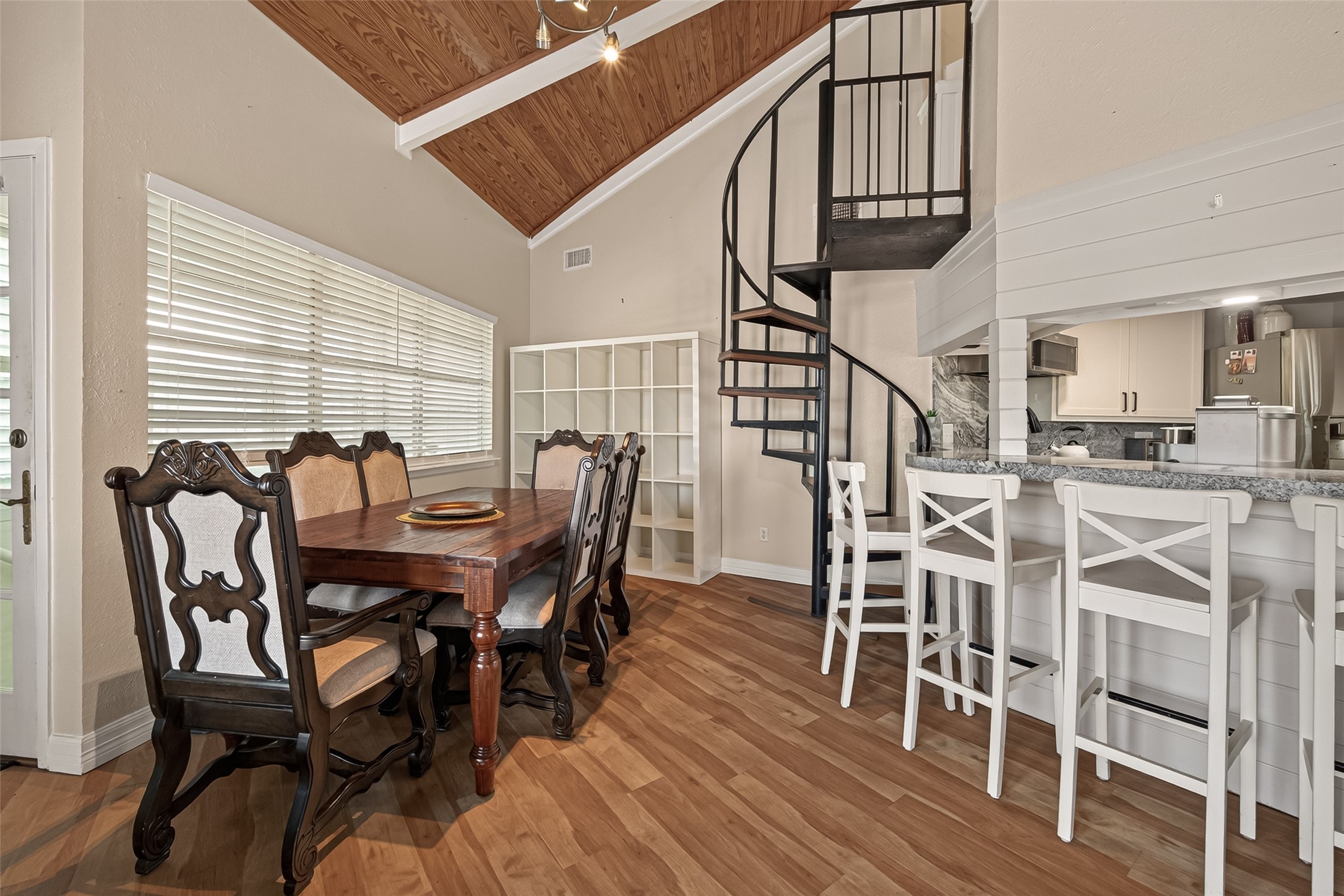 A charming dining setting tucked near a spiral staircase that rises to the private upper-level office. A charming dining setting tucked near a spiral staircase that rises to the private upper-level office.