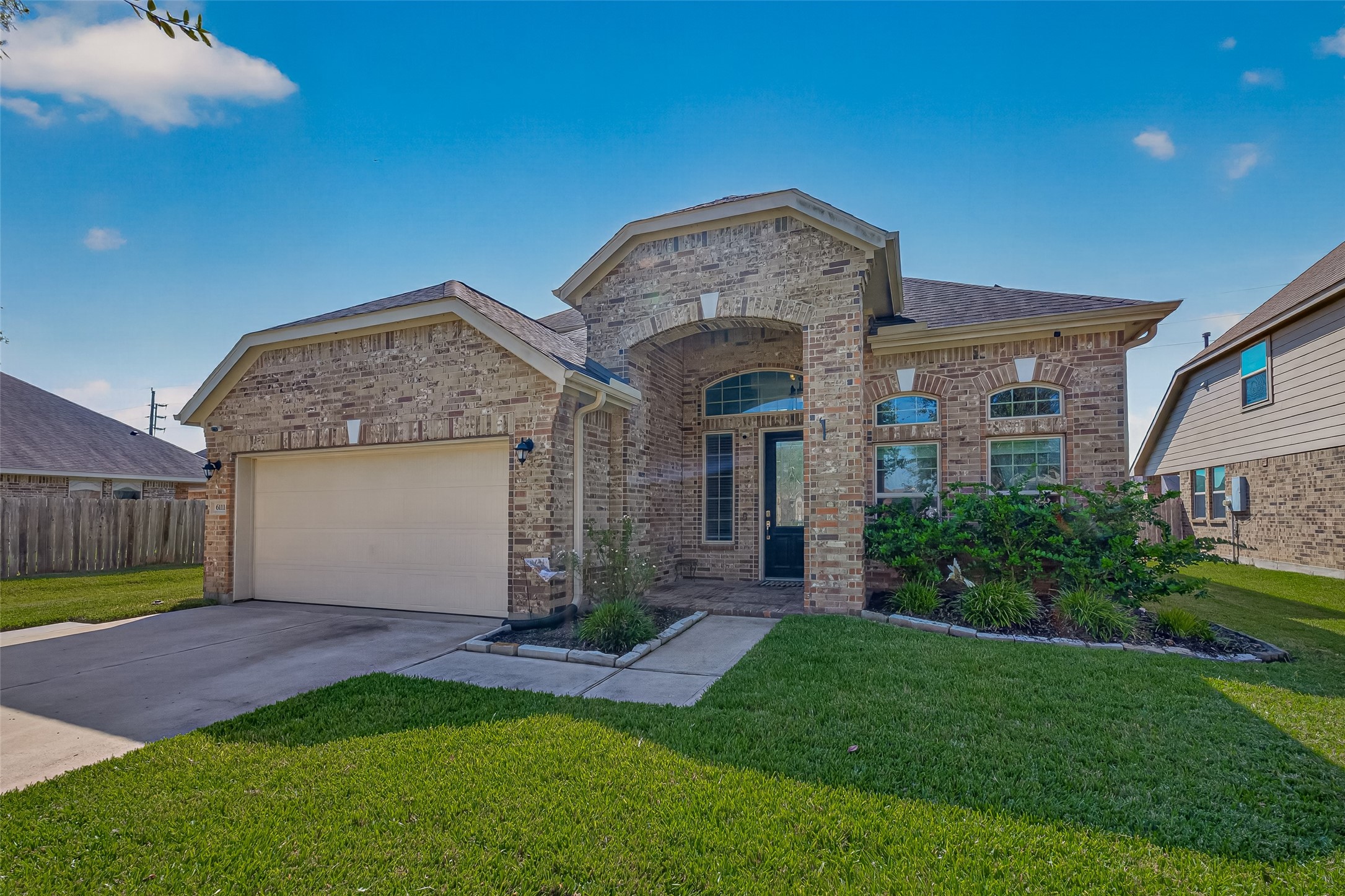 Another look at the brick exterior, arched entrance, and front lawn at 6111 Wayne Way.