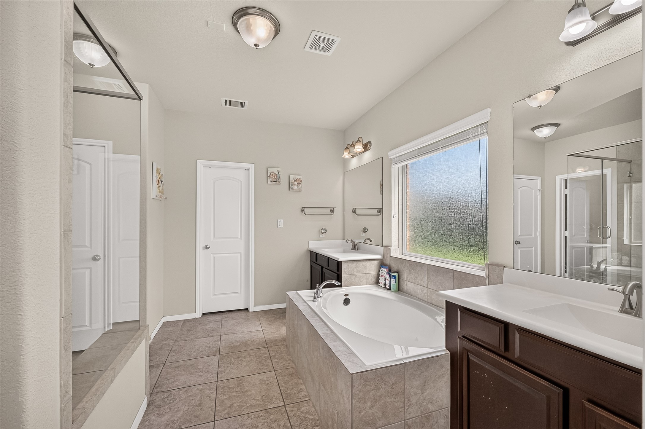 The primary bathroom pairs a soaking tub with a separate glass-enclosed shower.