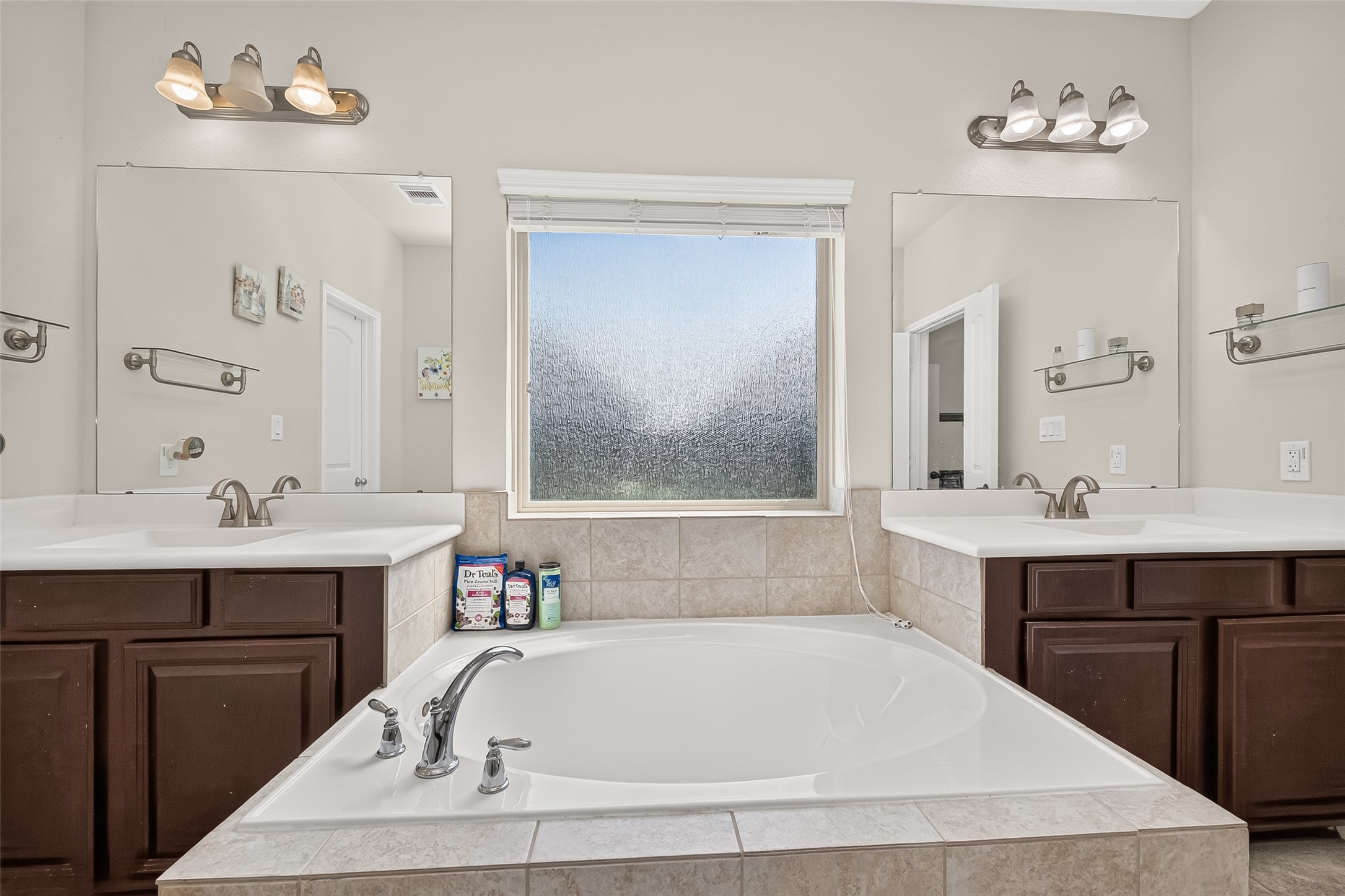 Separate vanities frame the soaking tub, creating room for everyday routines.