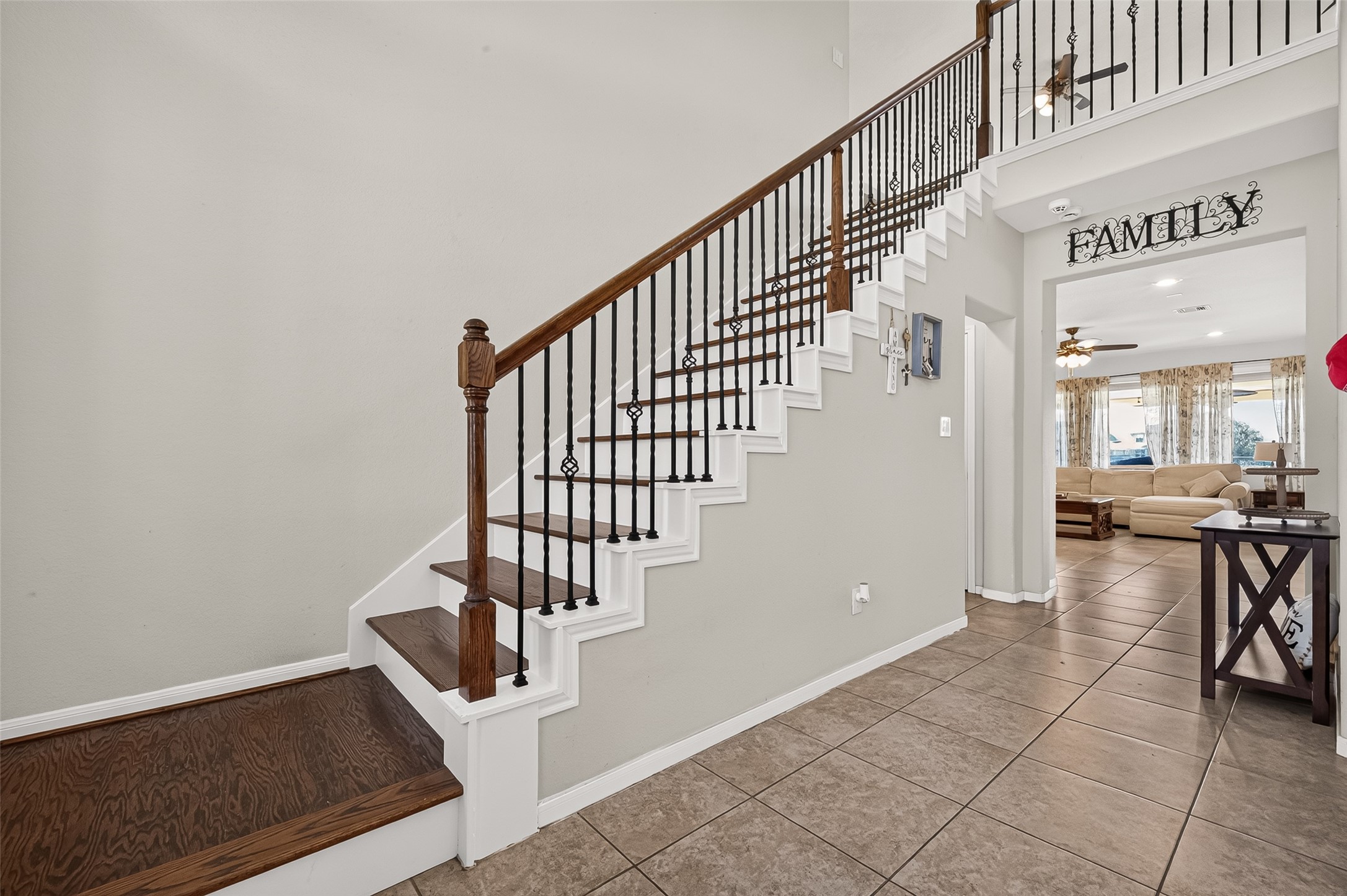 A wood staircase with decorative balusters leads to the upstairs living spaces.