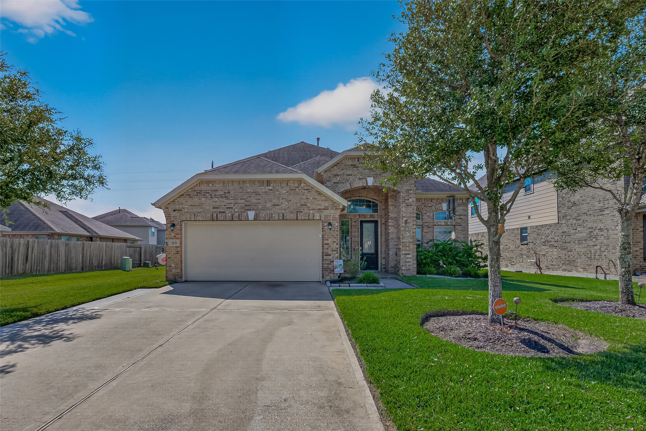 A wide driveway and attached garage complement the landscaped front yard at this Kingdom Heights home.