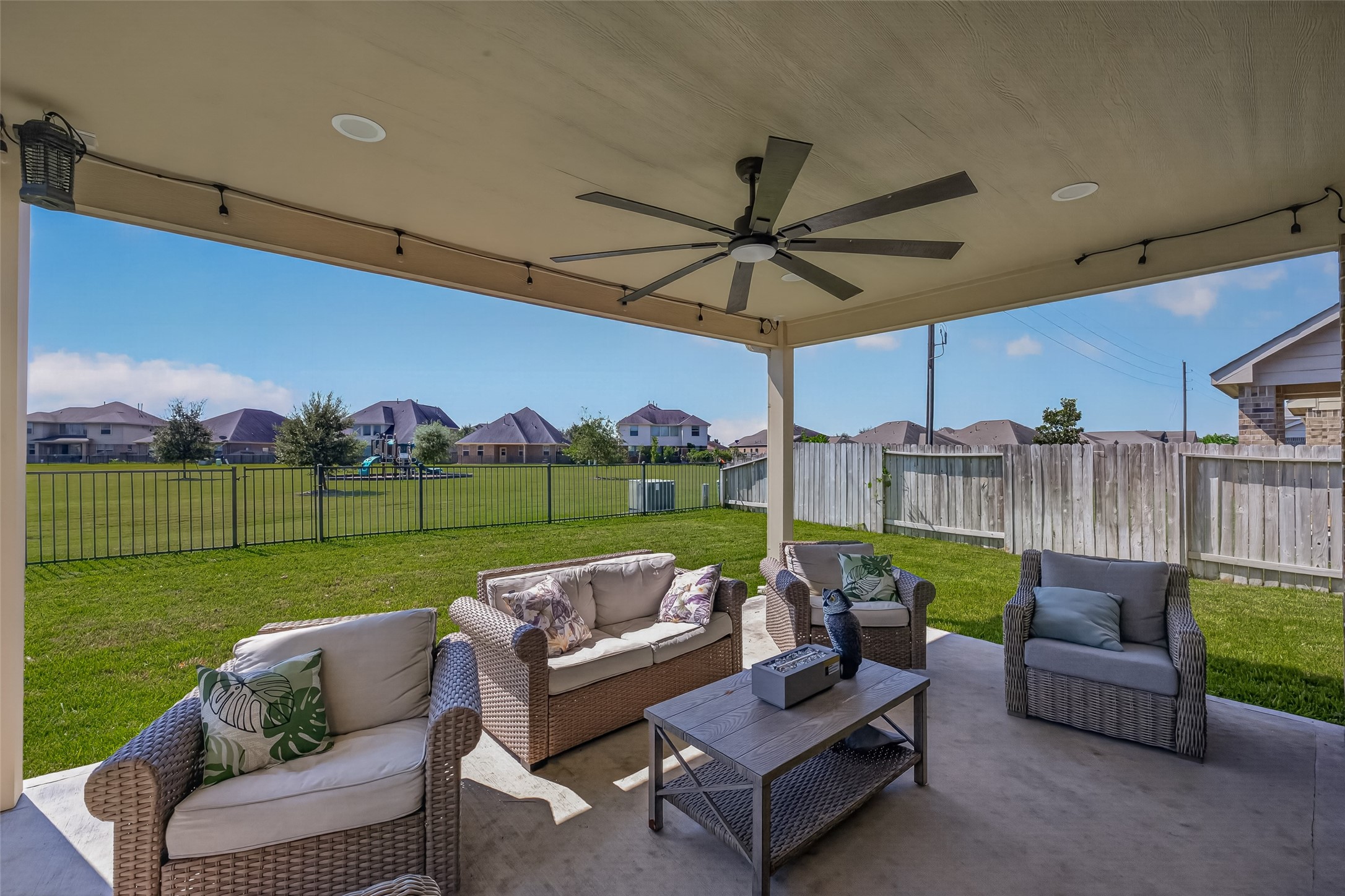 A spacious patio creates another gathering spot overlooking the fenced yard.