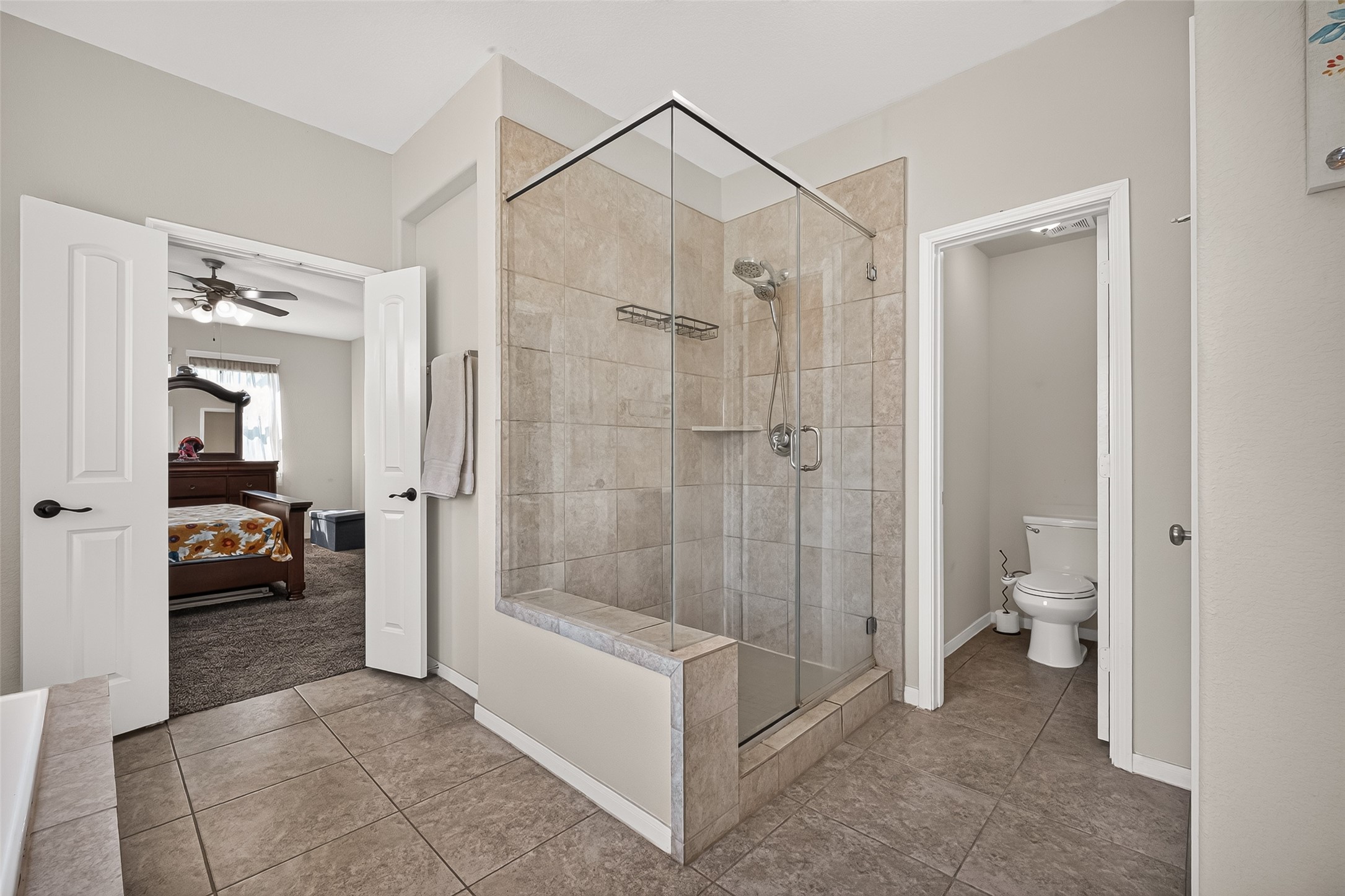 A closer look at the primary bathroom's walk-in shower and connection to the bedroom.
